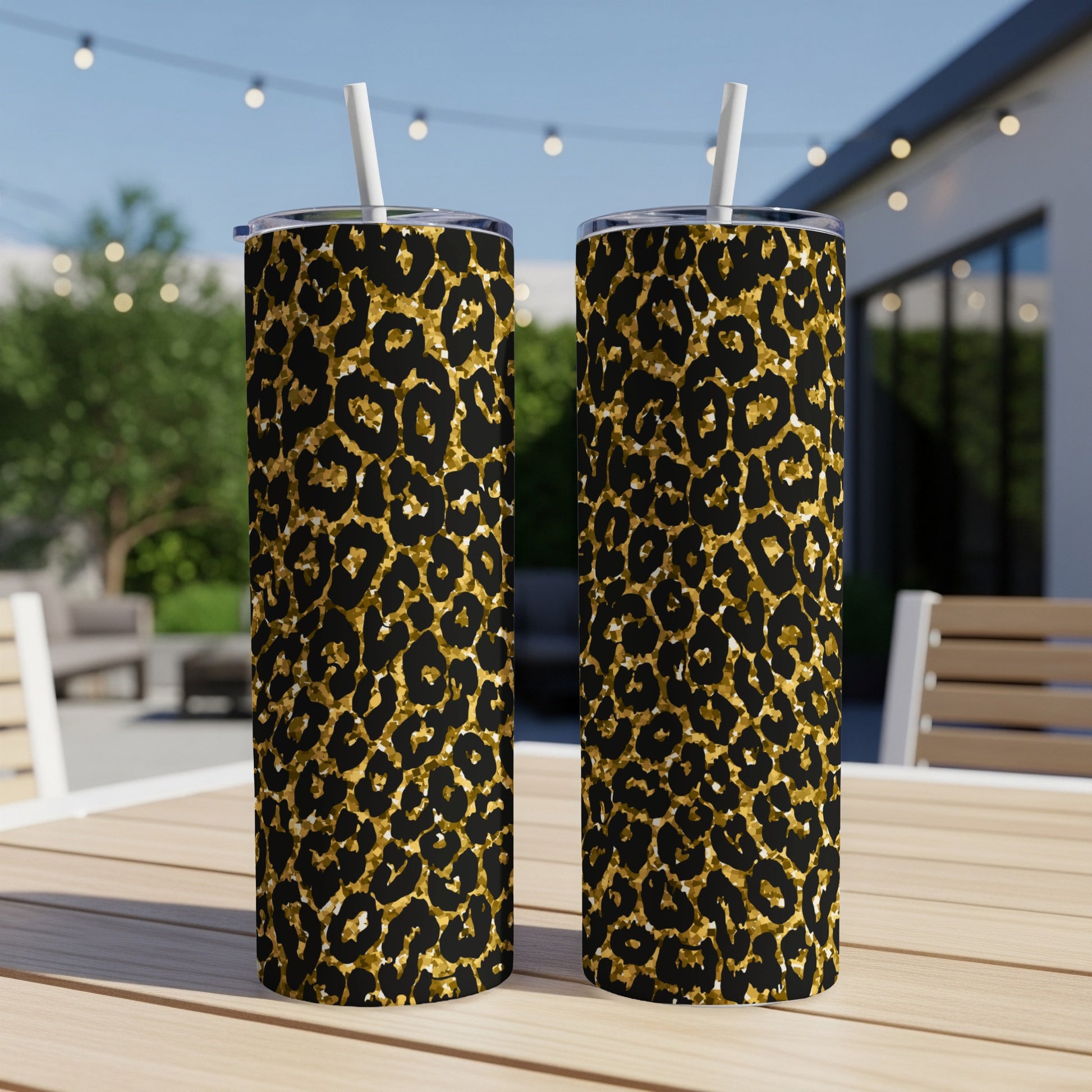 Two tall tumblers with a gold and black leopard print pattern on a table.