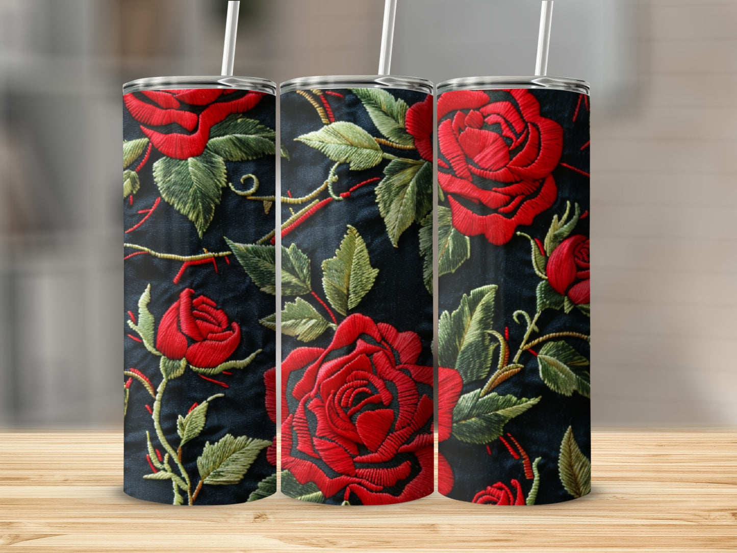 Three tumblers with a red rose embroidery pattern on a dark background.
