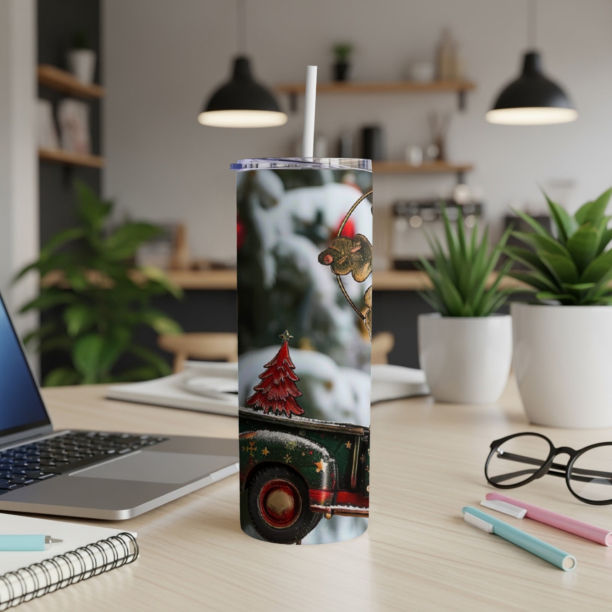 Tumbler with vintage Christmas truck design, laptop, and pens on desk.