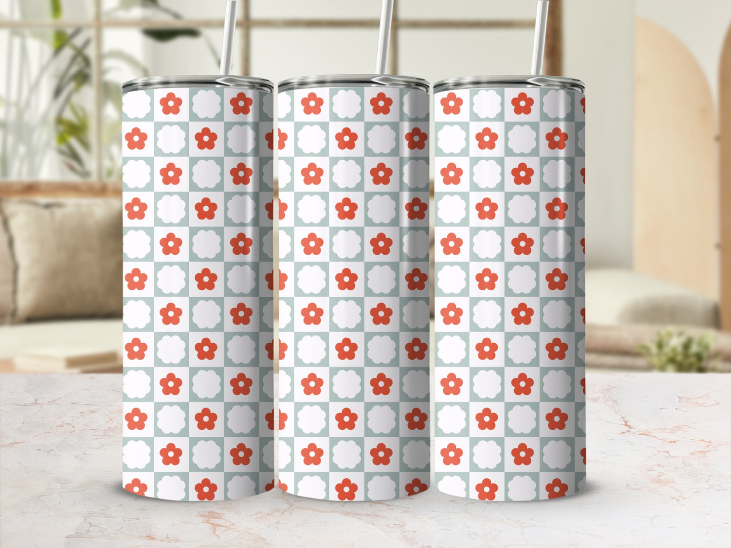 Three patterned tumblers with red flowers on a light blue checkered background.