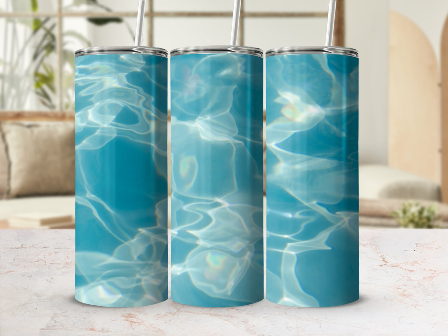 Three tumblers with a blue water ripple design on a marble surface.