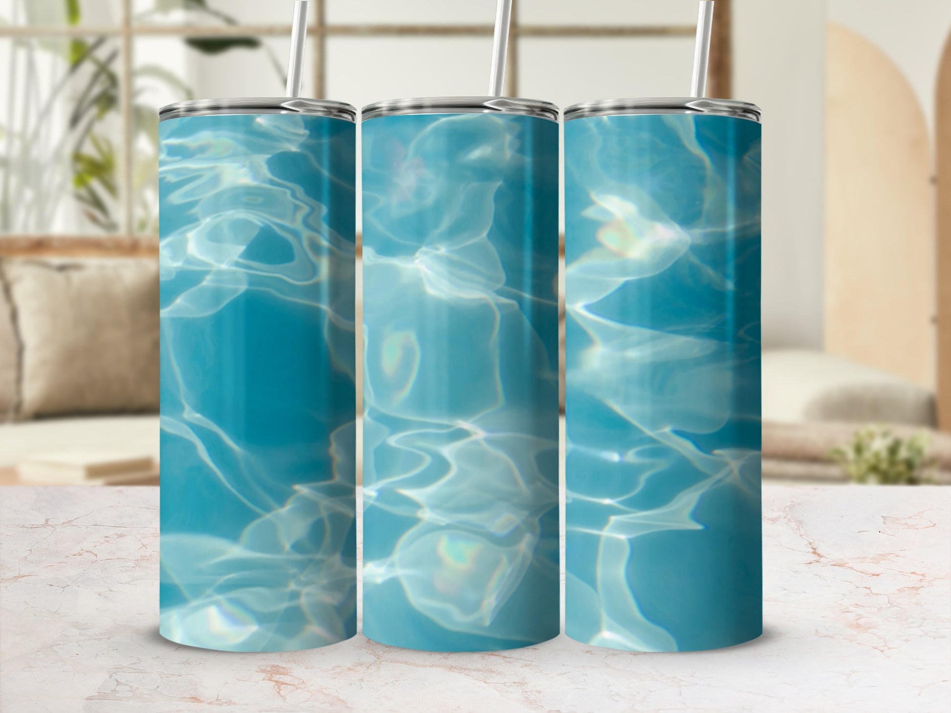 Three tumblers with a blue water ripple design on a marble surface.