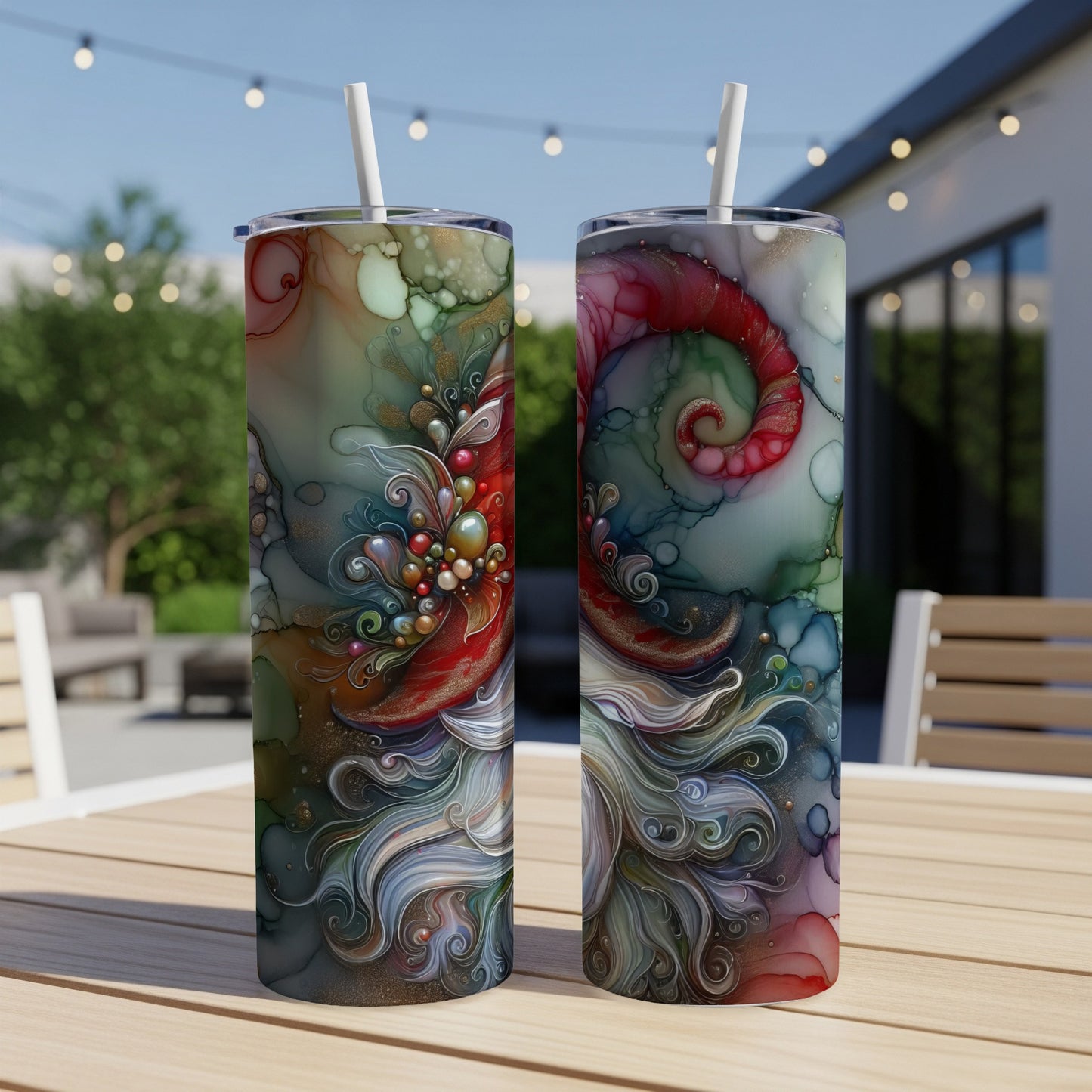 Two tumblers with colorful, abstract swirling designs on a wooden table outdoors.