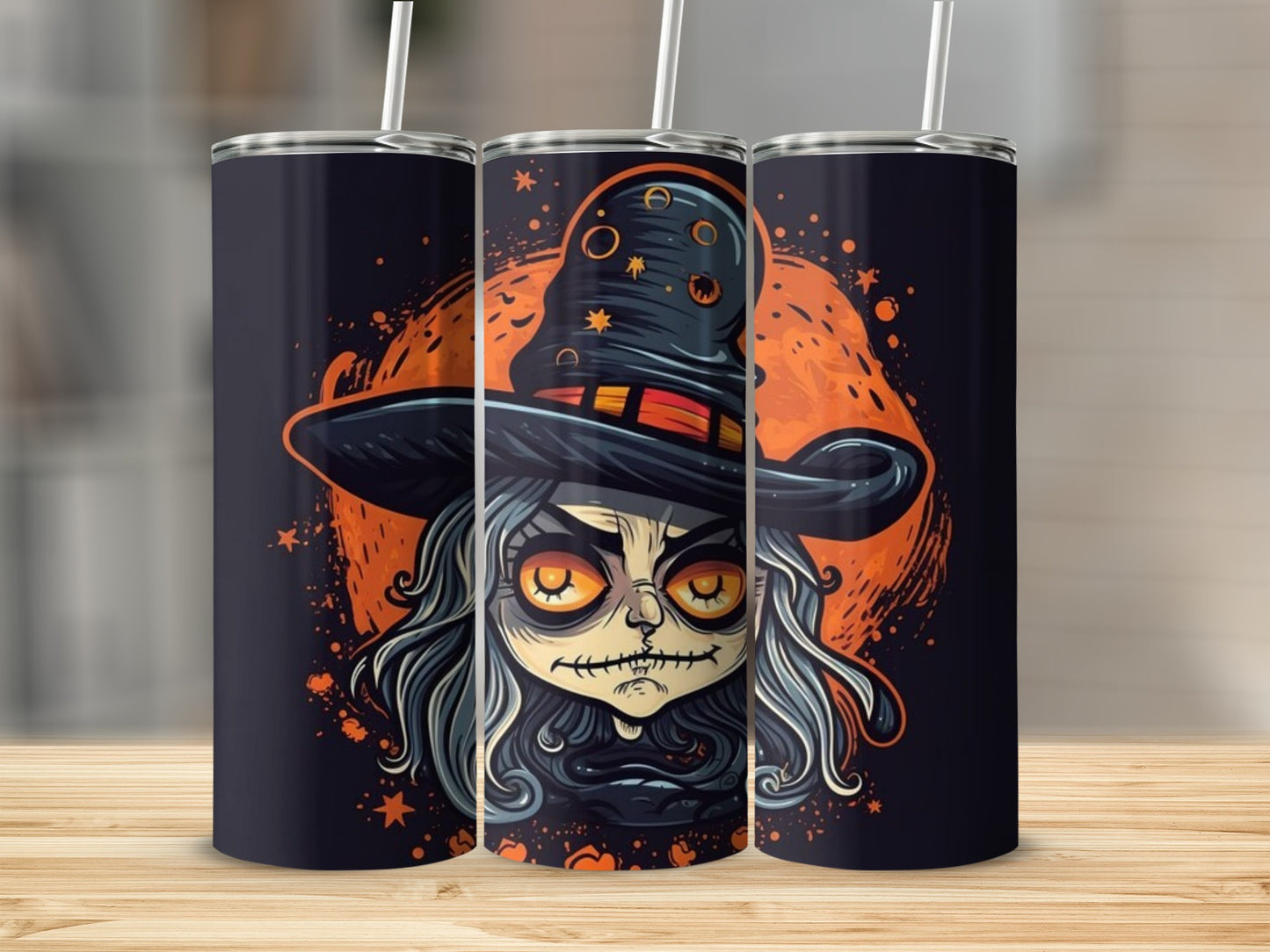 Three tumblers with spooky witch cartoon art and straws on a wooden surface.
