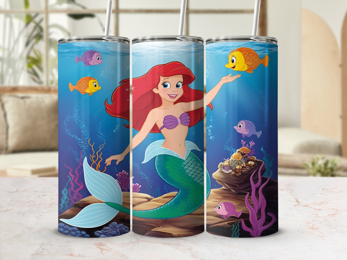 Ariel the mermaid, surrounded by colorful fish and coral, on a cylindrical tumbler.