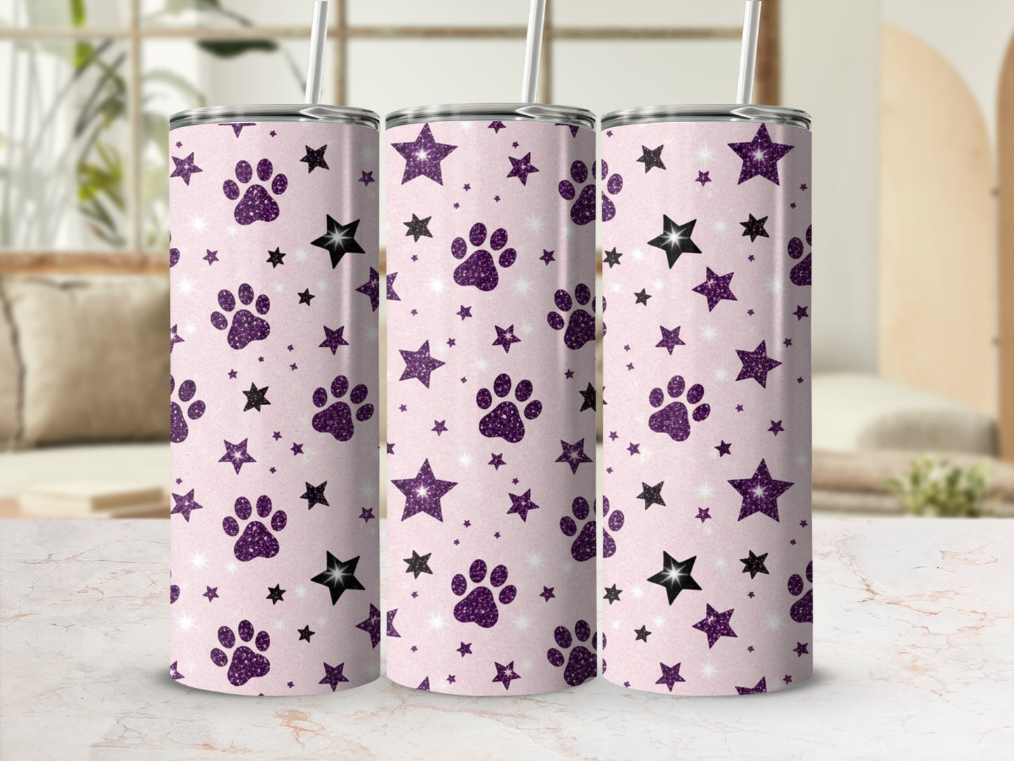 Three light pink tumblers with purple paw prints and black stars.