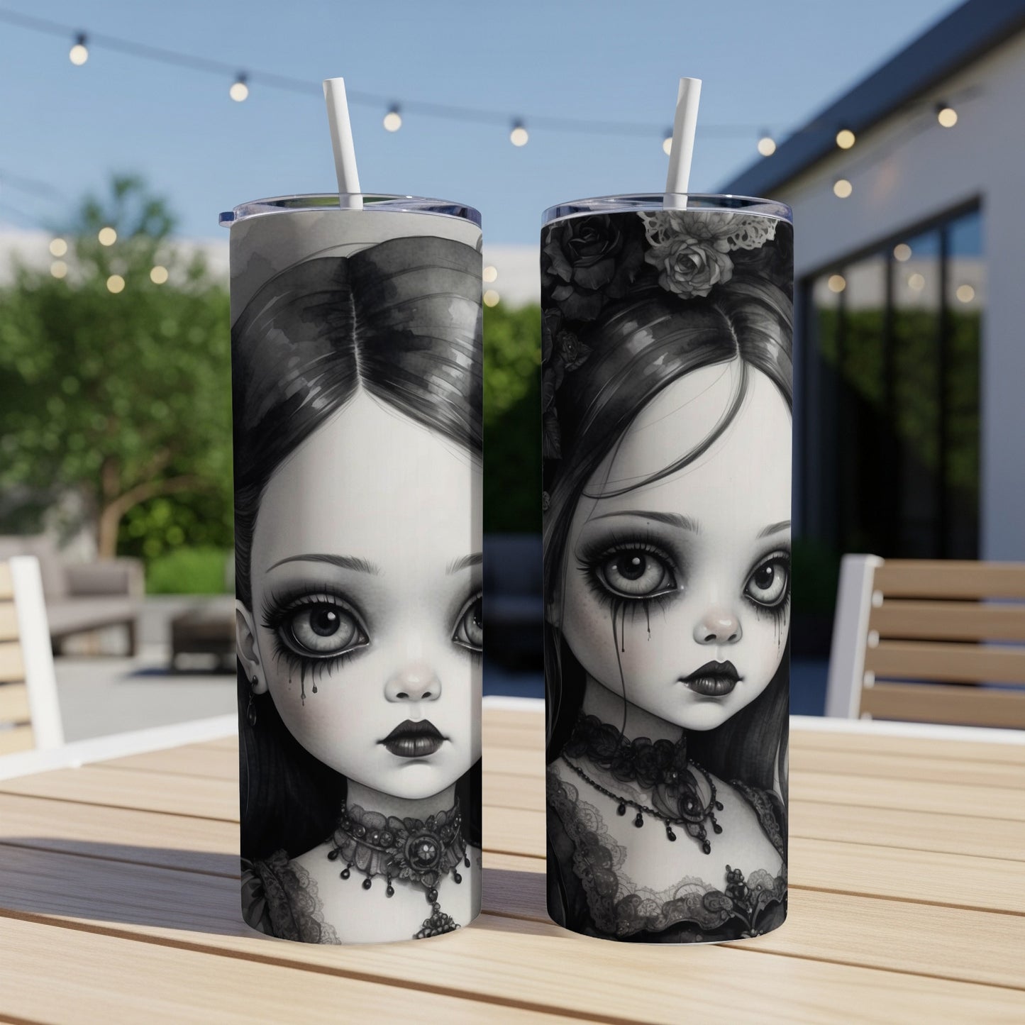 Two gothic doll-themed tumblers with large eyes and ornate necklaces on a wooden table.