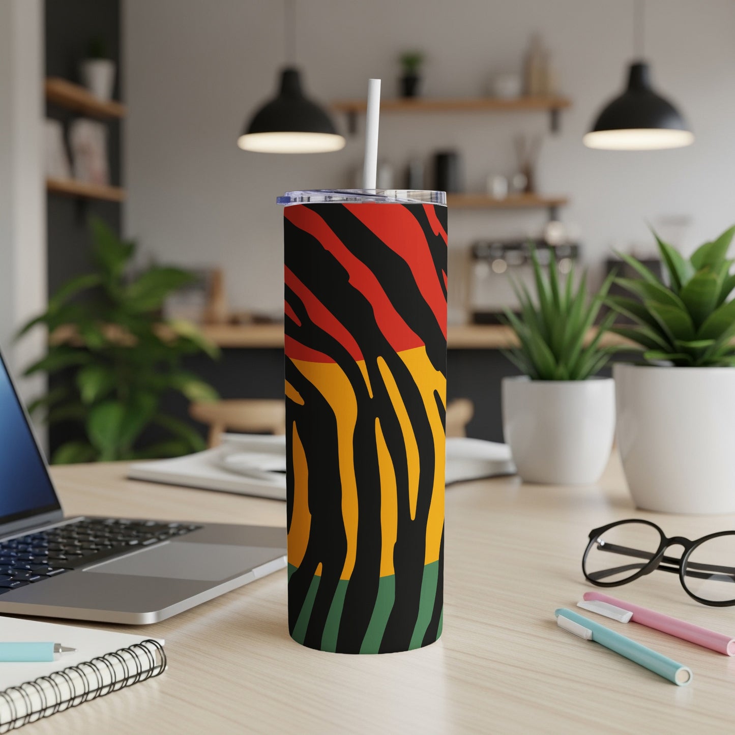 Tumbler with red, yellow, black, and green abstract stripe pattern.
