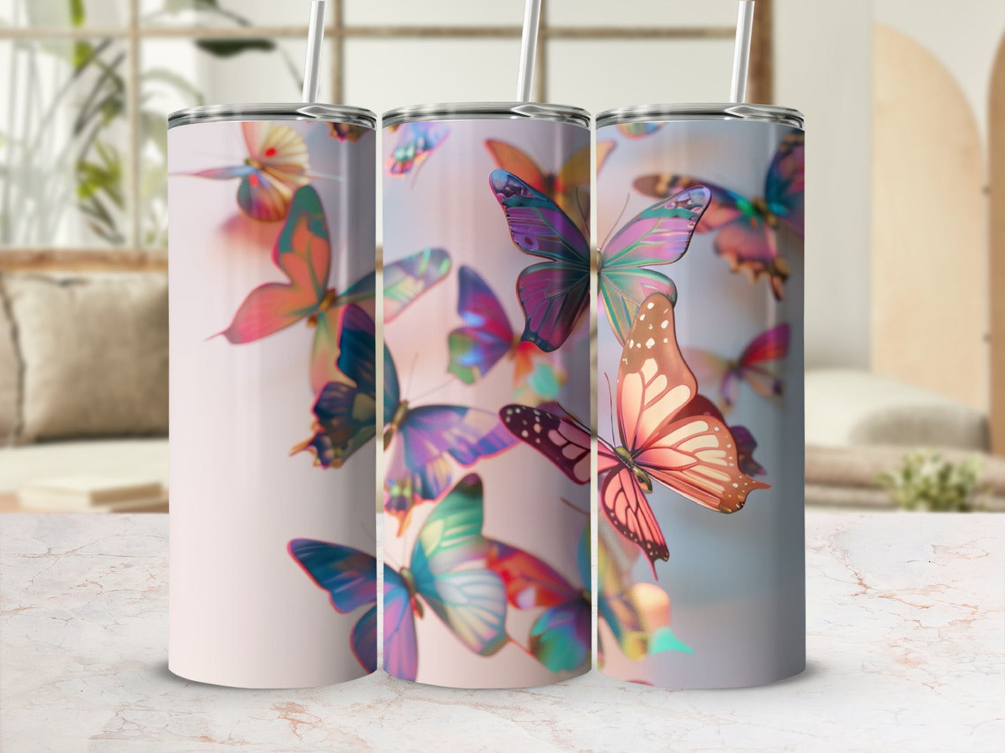 Three tumblers with iridescent butterfly designs and straws.