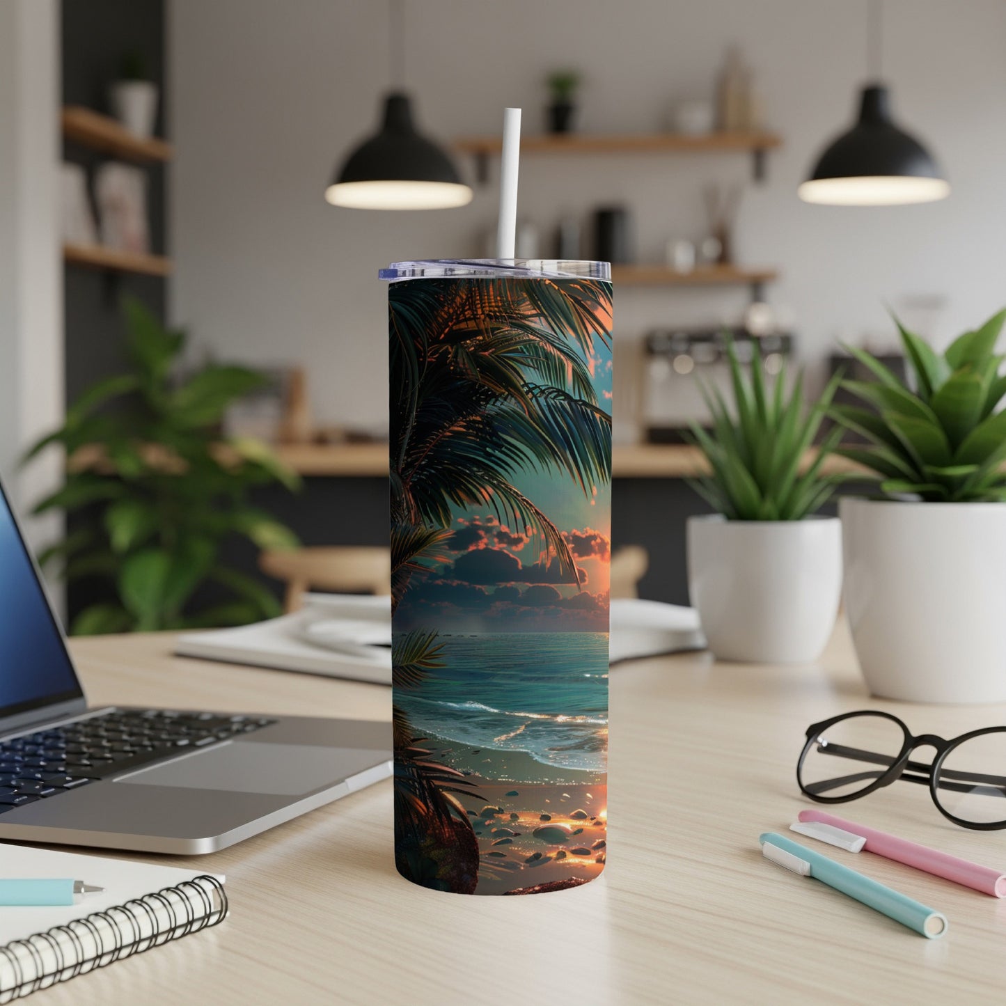 Tall tumbler with tropical beach sunset design on a desk.