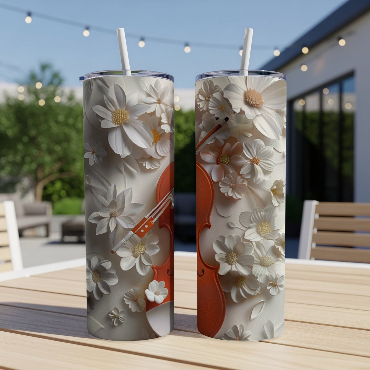 Two tumblers with white flowers and a violin design on a table.