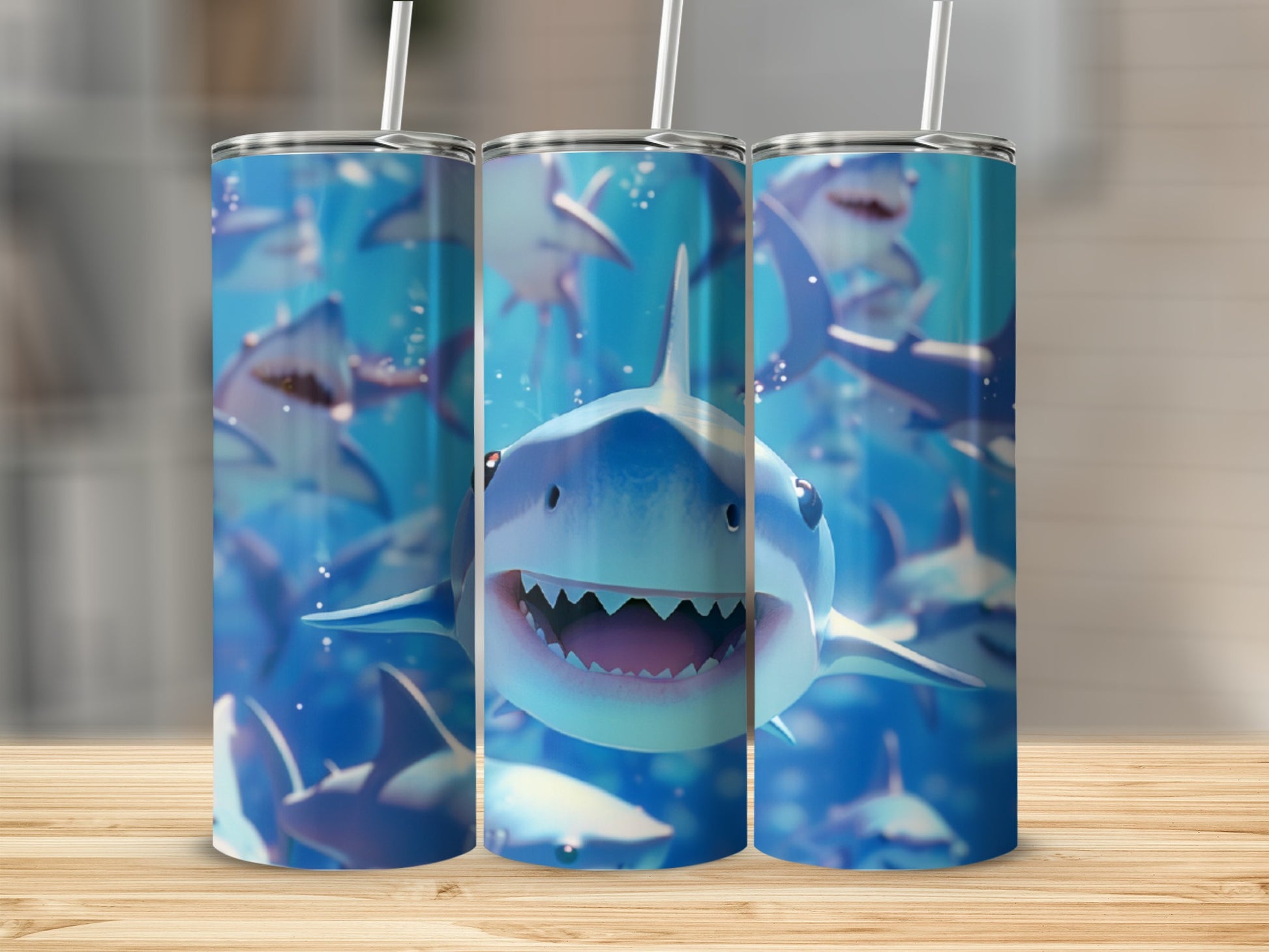 Three tumblers with cartoon shark design and straws, on a wooden surface.