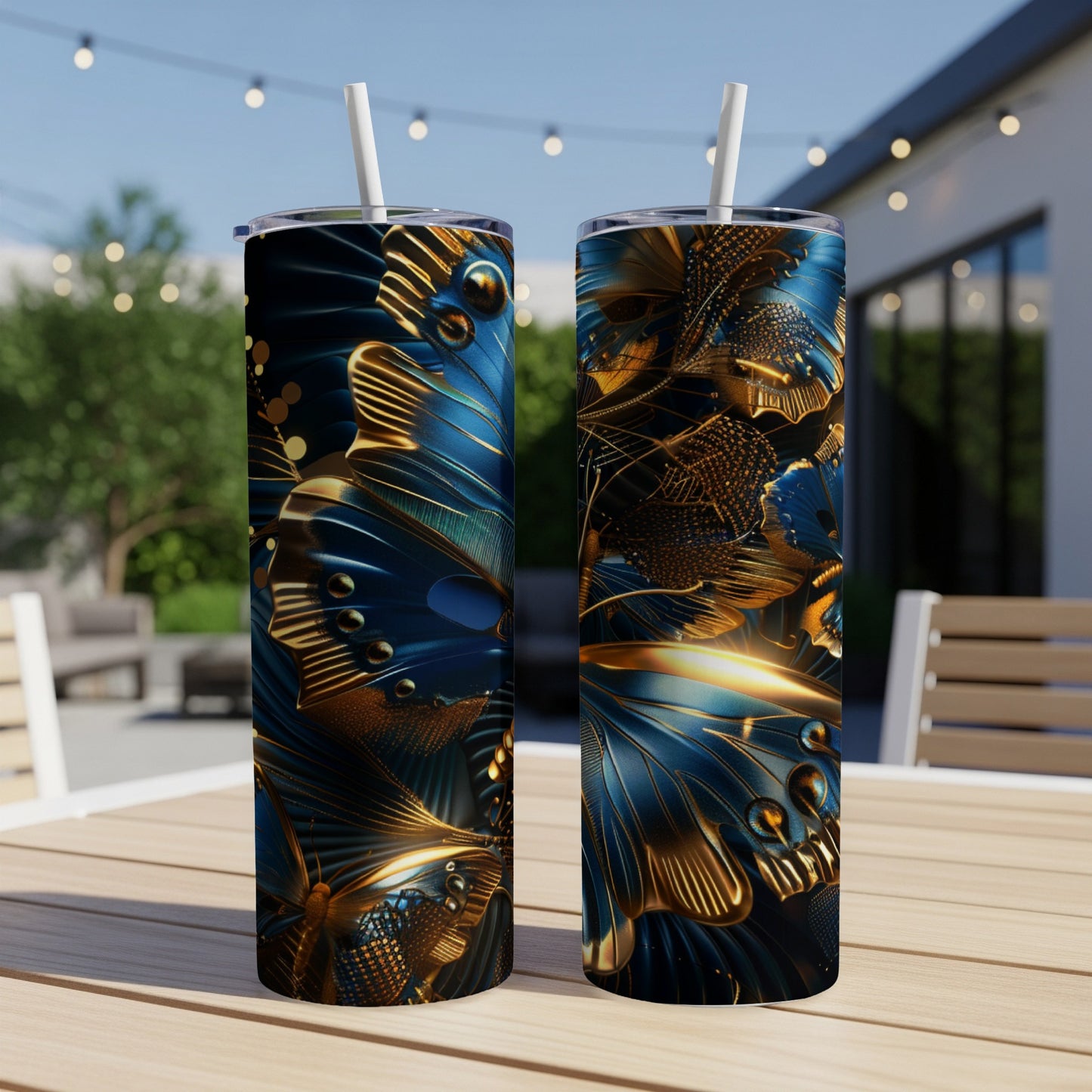 Two tall, patterned tumblers with gold and blue butterfly wings on a patio table.