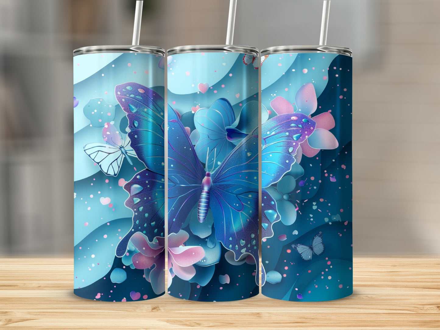Three blue tumblers with iridescent butterfly and floral designs.