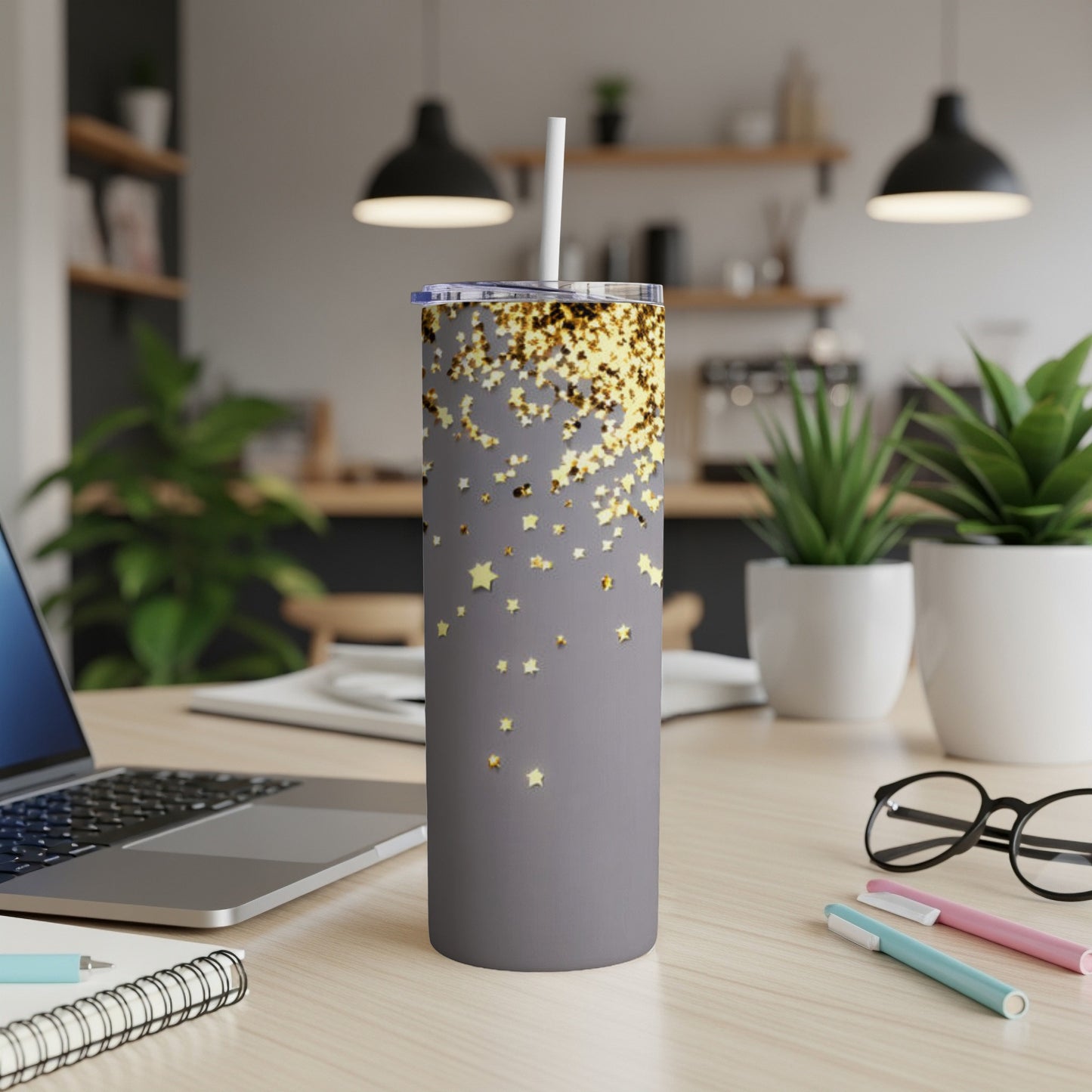 Gray tumbler with gold star confetti pattern and white straw.