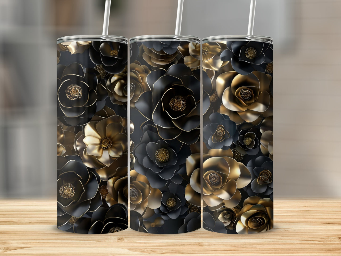 Three black and gold floral tumblers on a wooden surface.