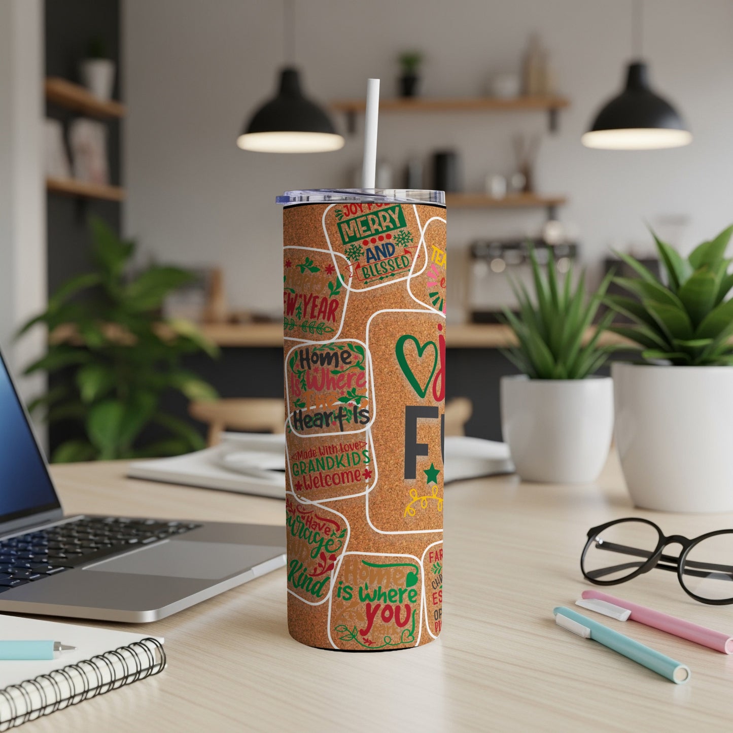 Tumbler with colorful holiday and family phrases on a cork-like background.