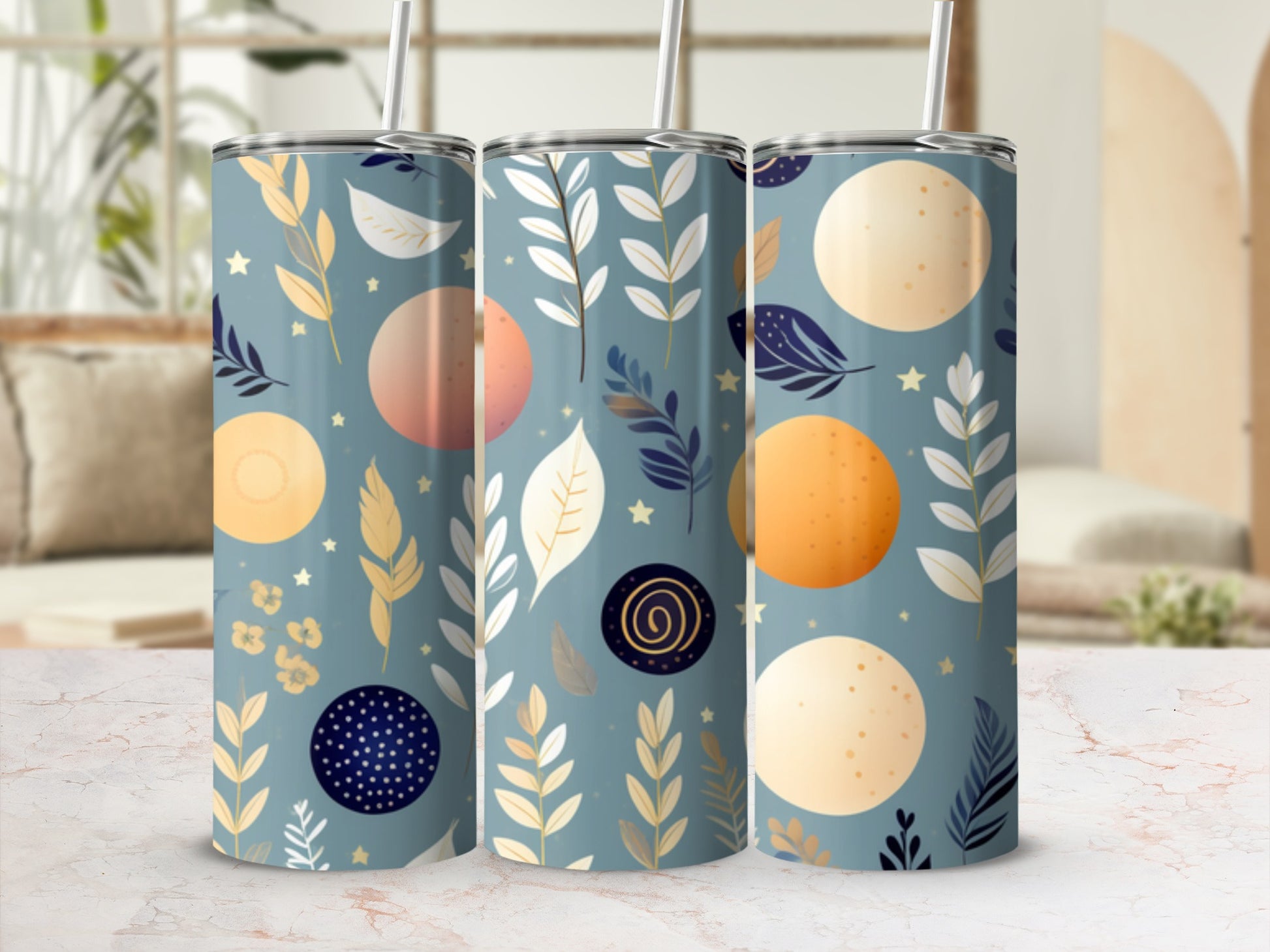 Three tumblers with celestial moon and leaf pattern on a light marble surface.