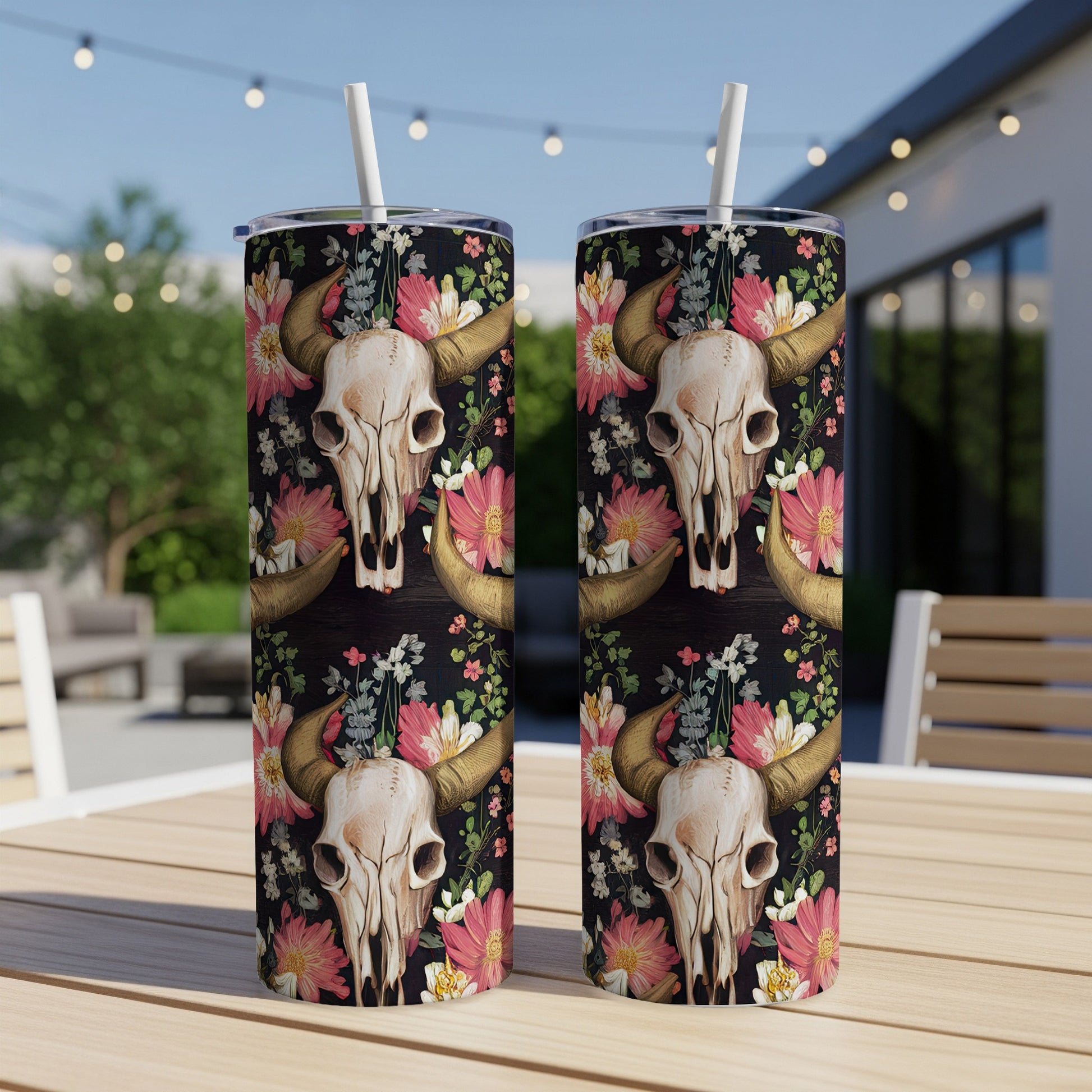Steer skull and floral pattern on two tumblers on a wooden table.