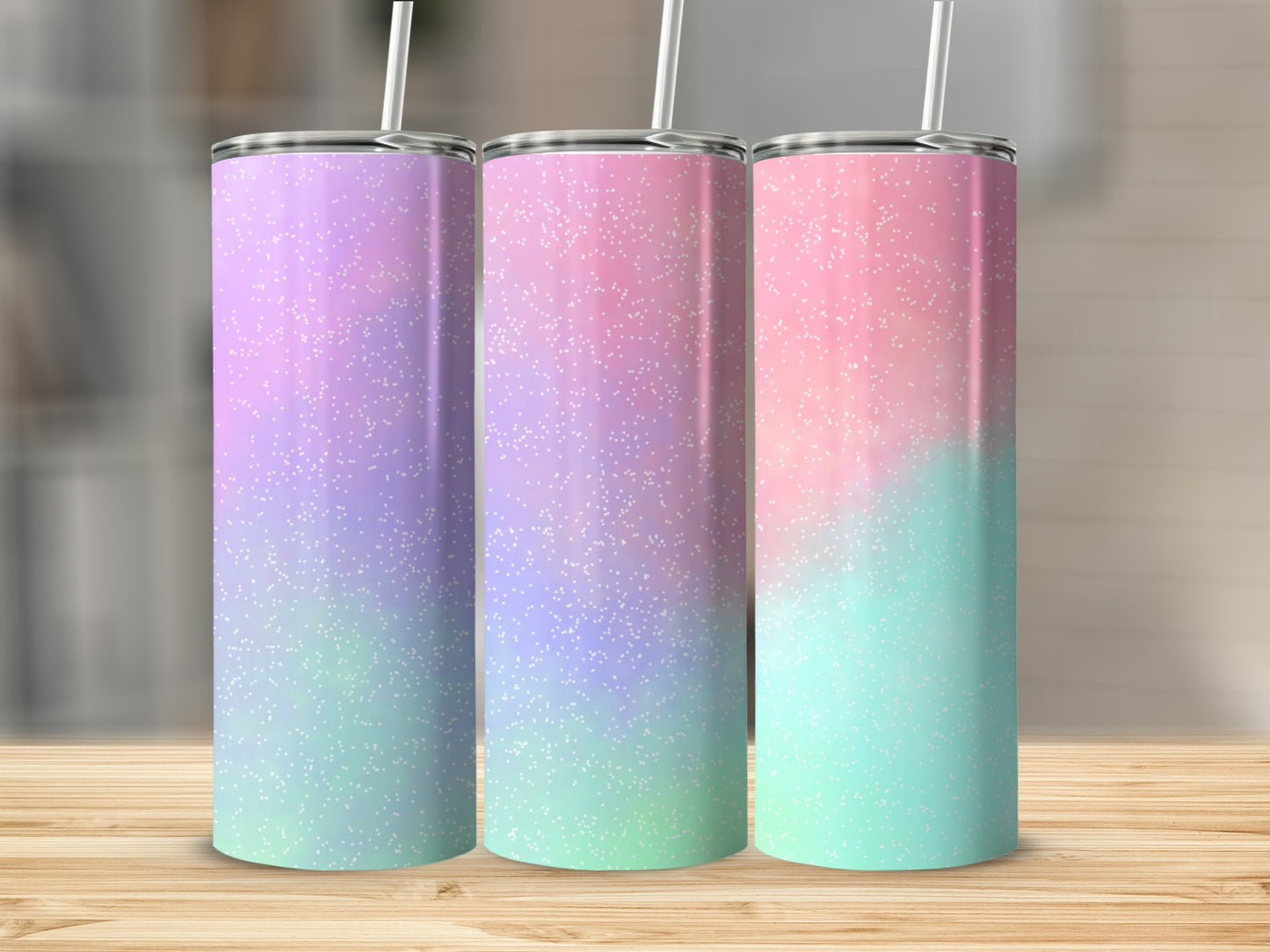 Three colorful tumbler cups with glitter accents on a wooden surface.