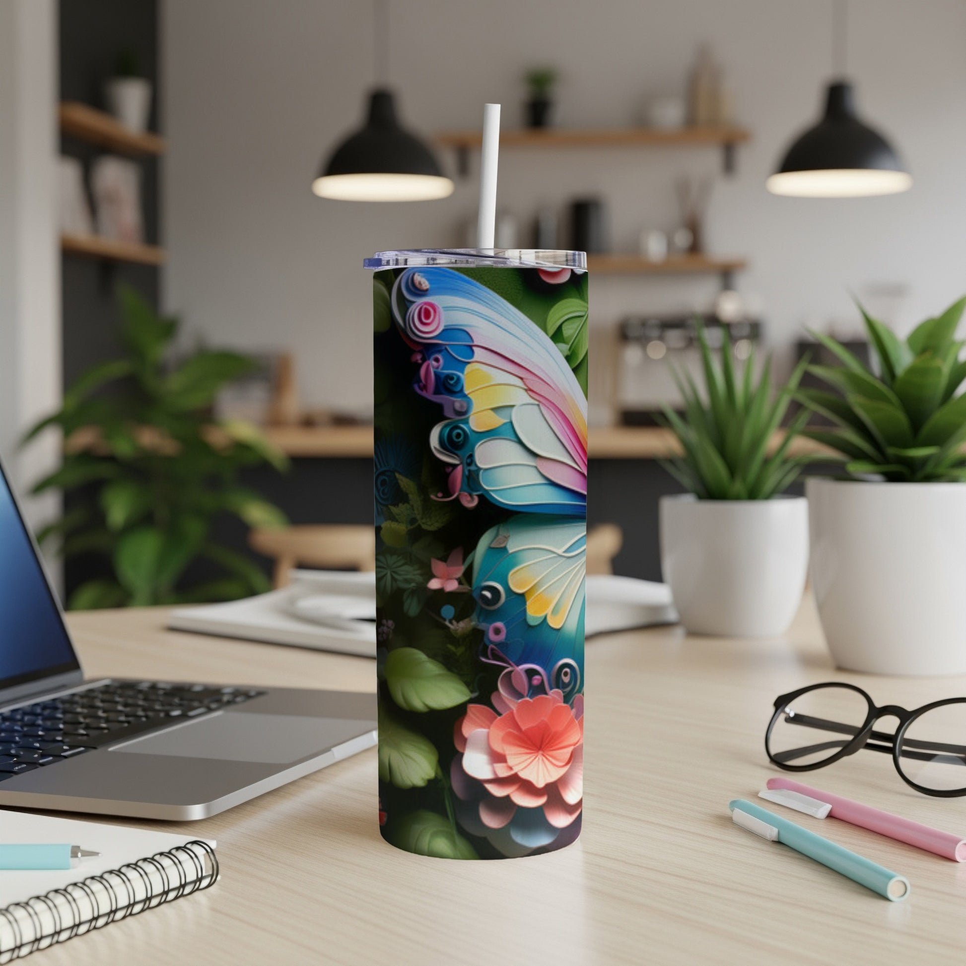 Butterfly and flower design on a skinny tumbler with a straw.