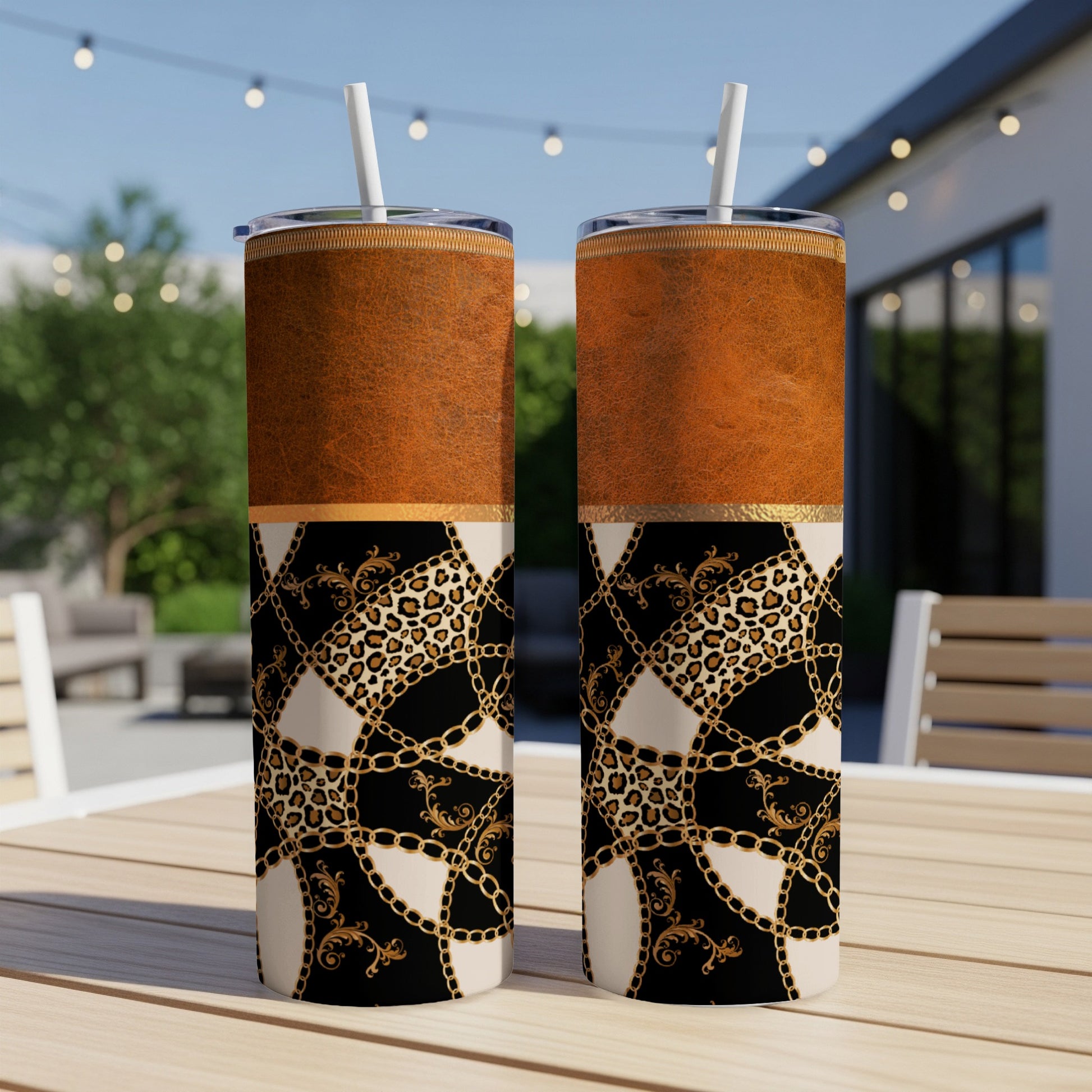 Two tumblers with leopard print, gold chain, and ornate designs on a table.