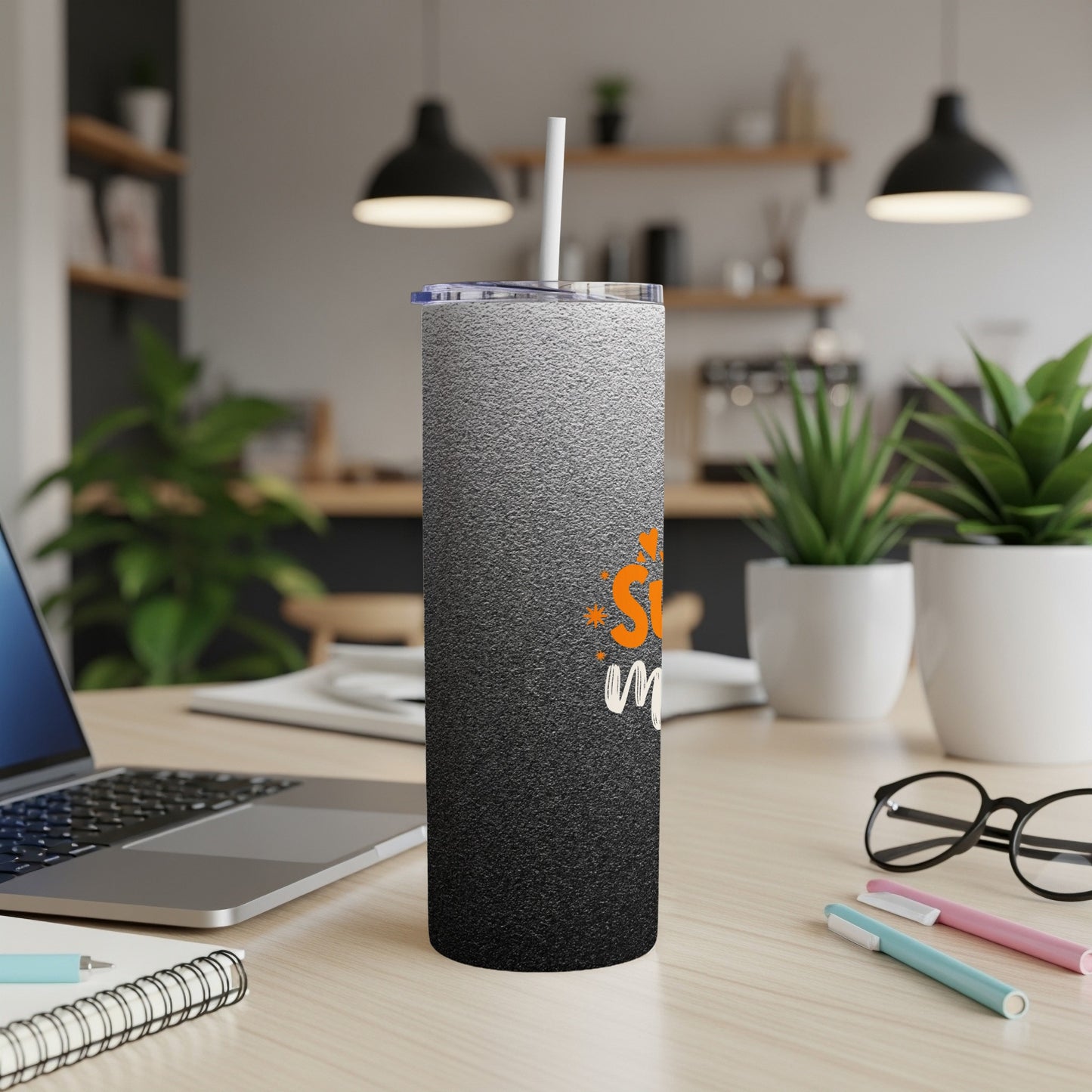 Black and white gradient tumbler with orange "Ski" text on a desk.