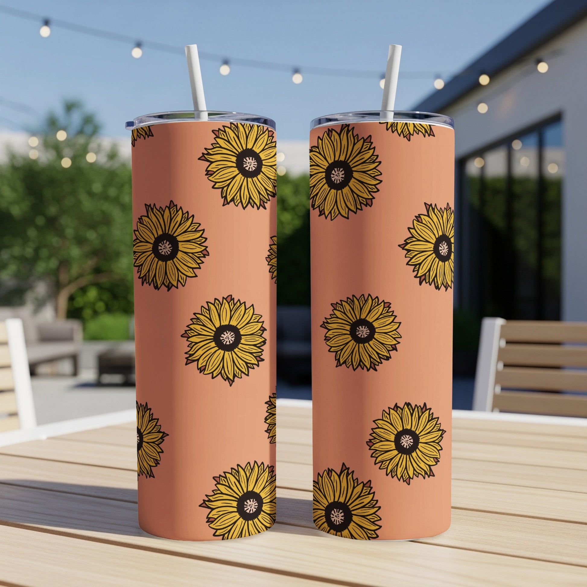 Two tall tumblers with a repeated sunflower pattern on an orange background.