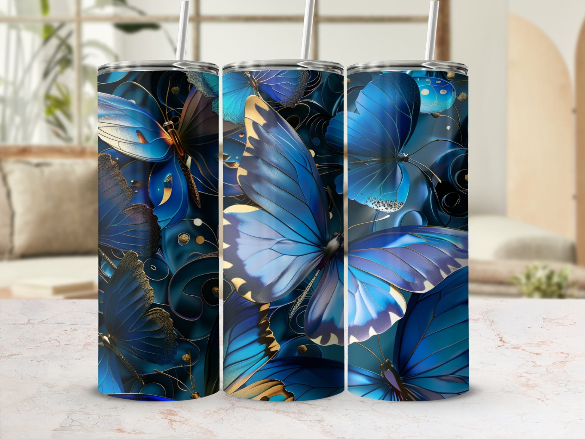 Three blue butterfly tumblers with gold accents and straw.