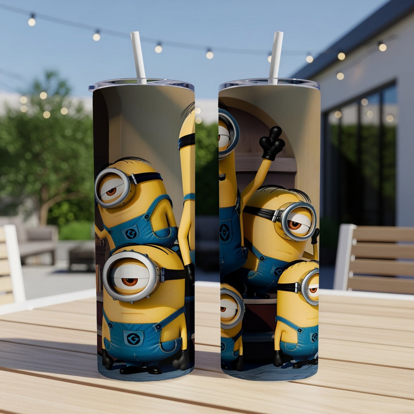 Minions in blue overalls stand on a wooden table with a straw in each tumbler.