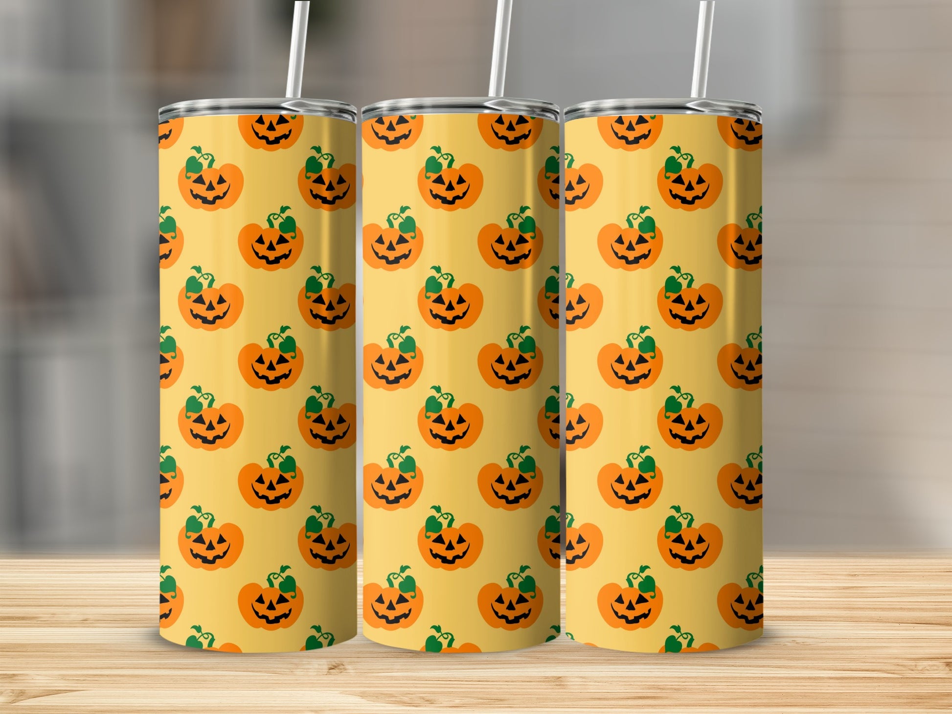 Three tumblers with a repeated pattern of Halloween jack-o'-lanterns on a yellow background.