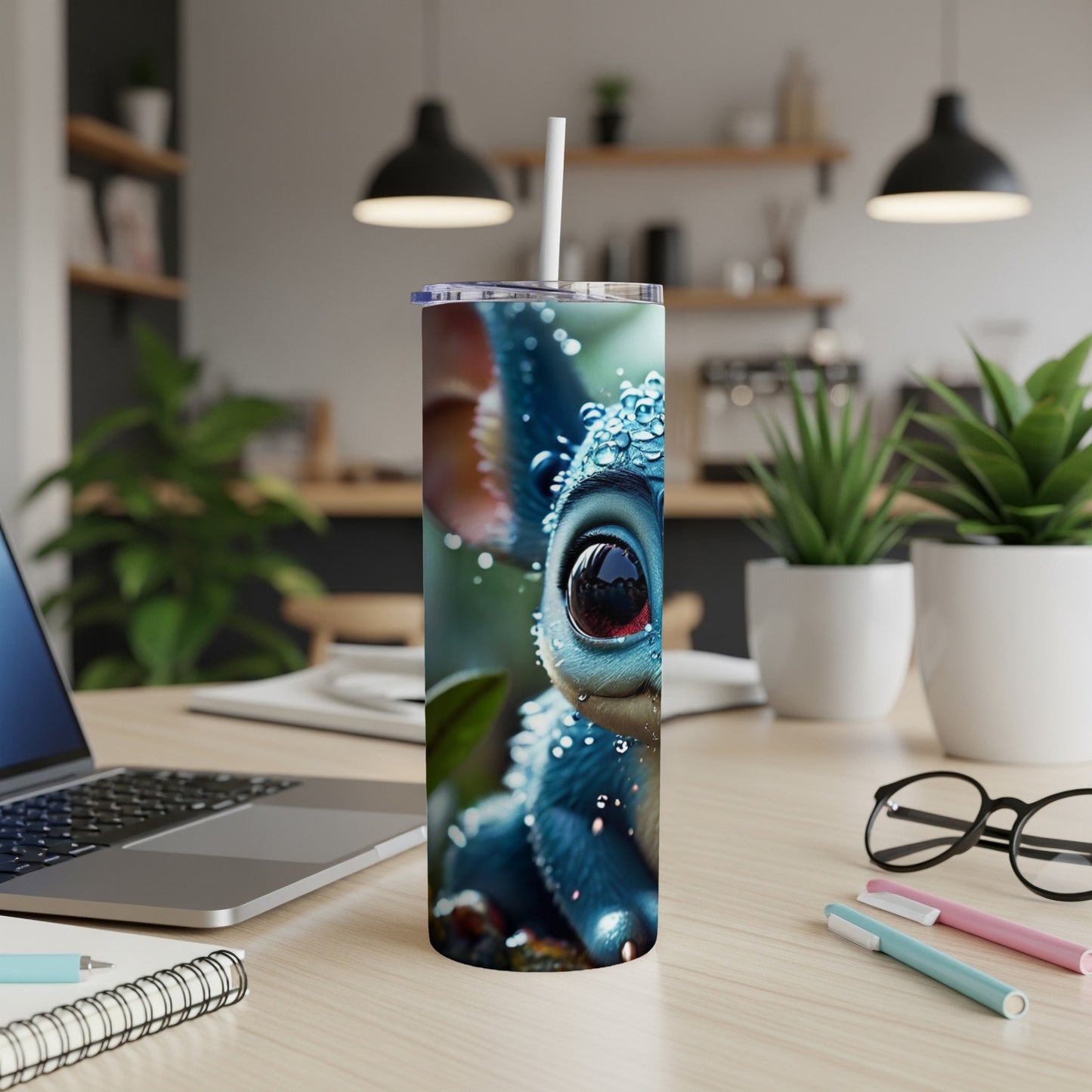 Blue cartoon creature with big eyes on a tumbler with straw.