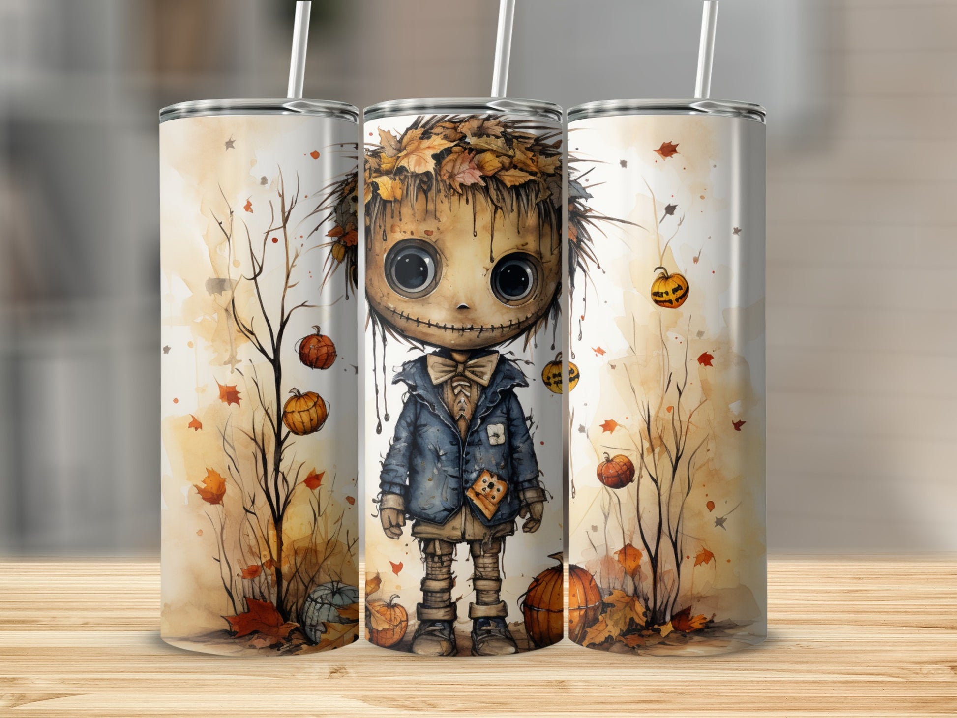 Three tumblers with a whimsical scarecrow, autumn leaves, and pumpkins in watercolor style.