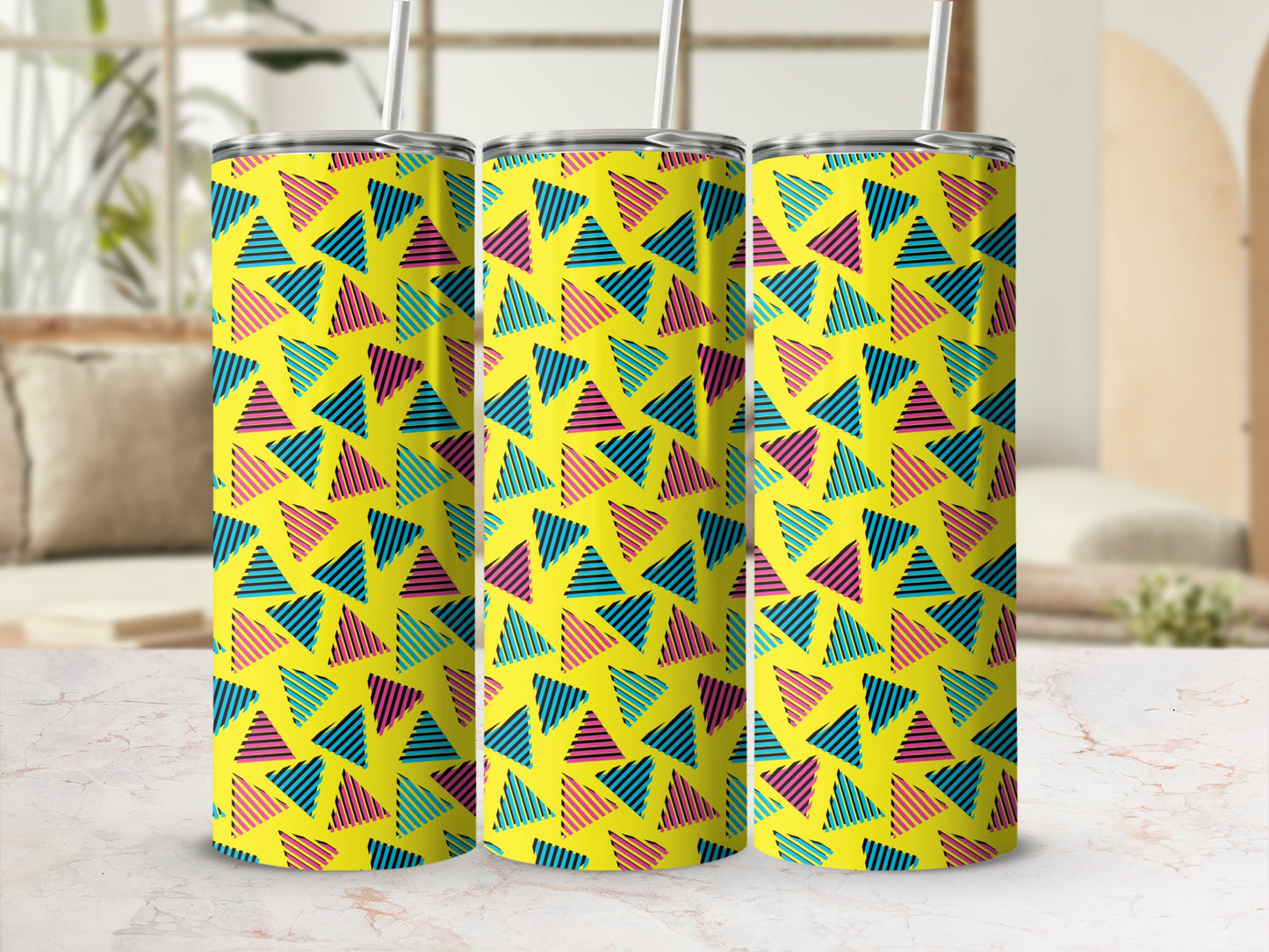 Three tumblers with a yellow background and a pattern of striped triangles in blue, pink, and black.
