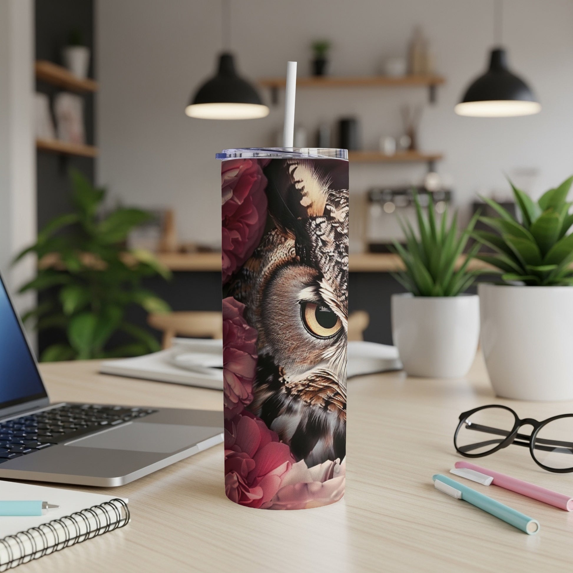 Close-up of an owl's eye surrounded by deep red roses on a tumbler.