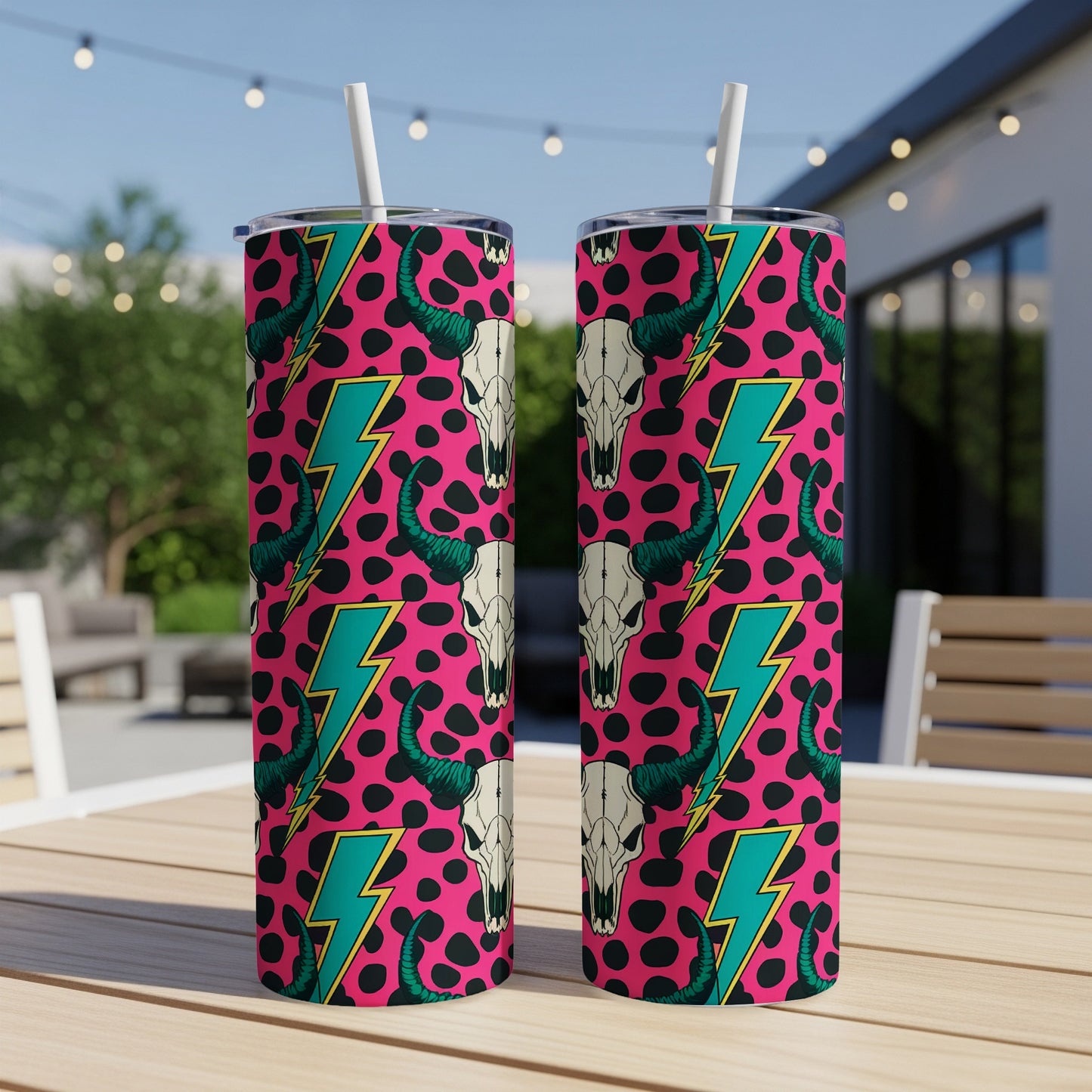 Two tumblers with pink background, black cow skulls, and teal lightning bolts.