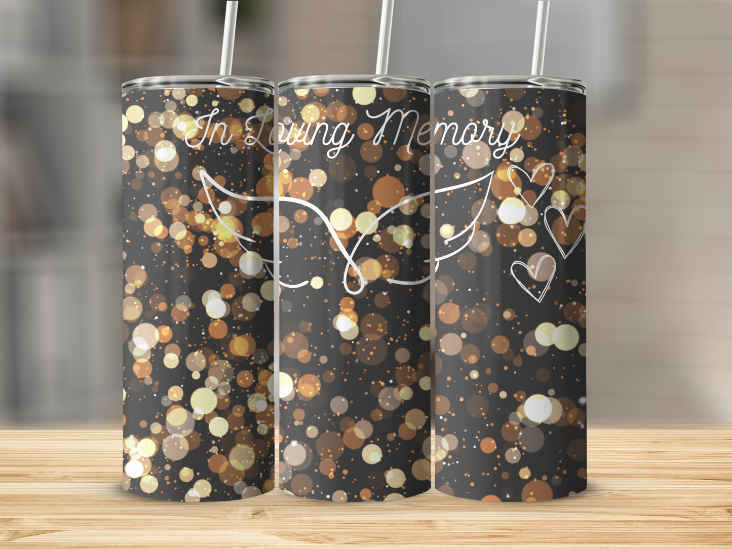 Tumbler with "In Loving Memory" text, hearts, and angel wings on a bokeh background.