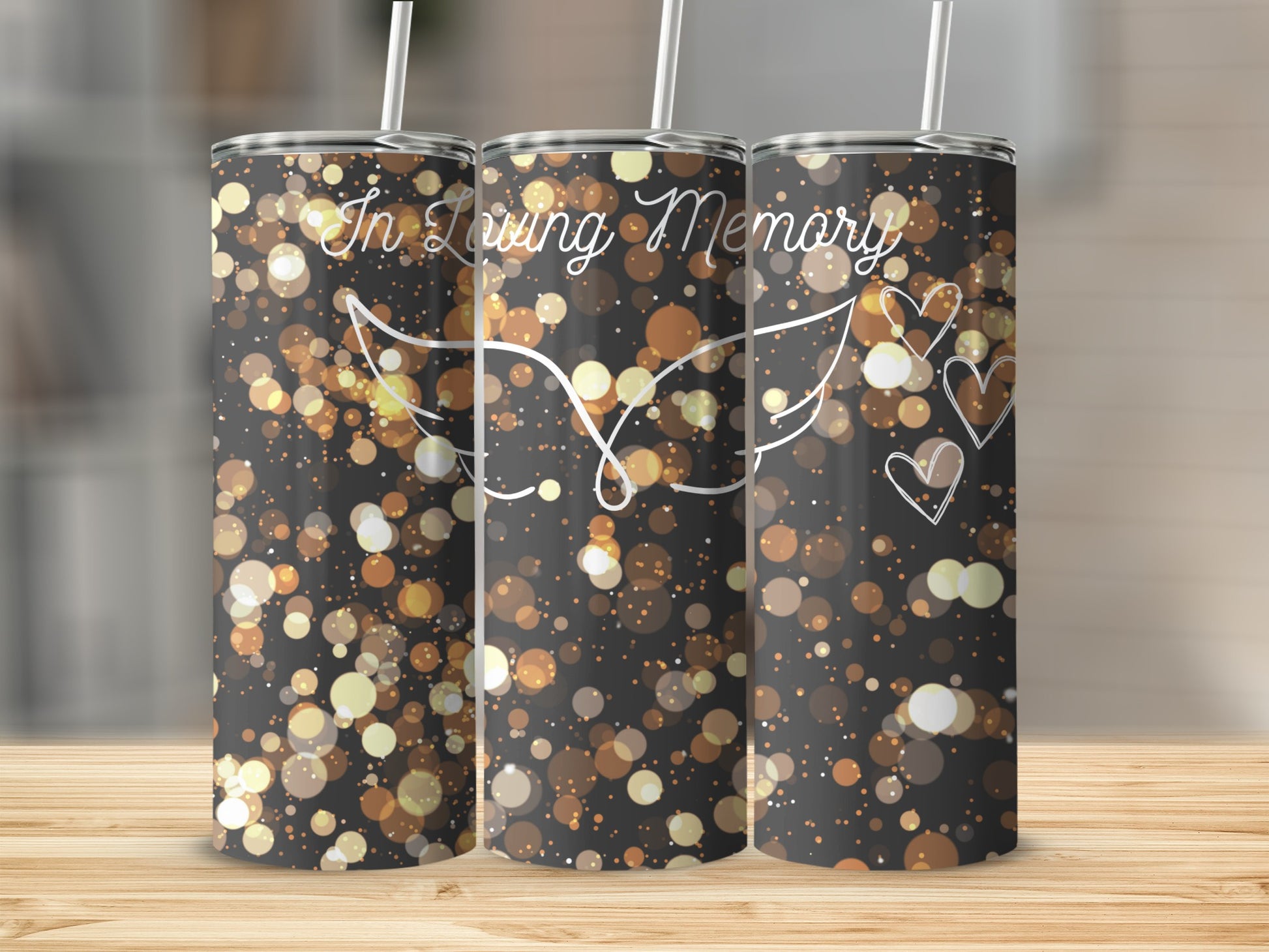 Tumbler with "In Loving Memory" text, hearts, and angel wings on a bokeh background.