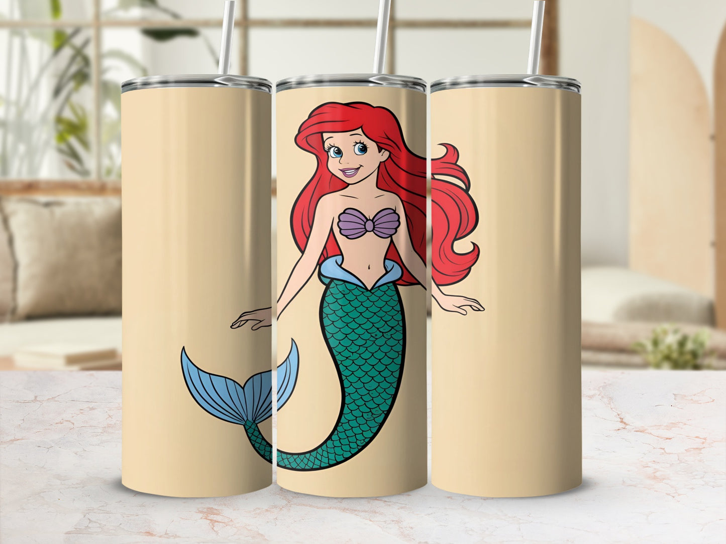 Ariel the mermaid on three tan tumblers with straws.