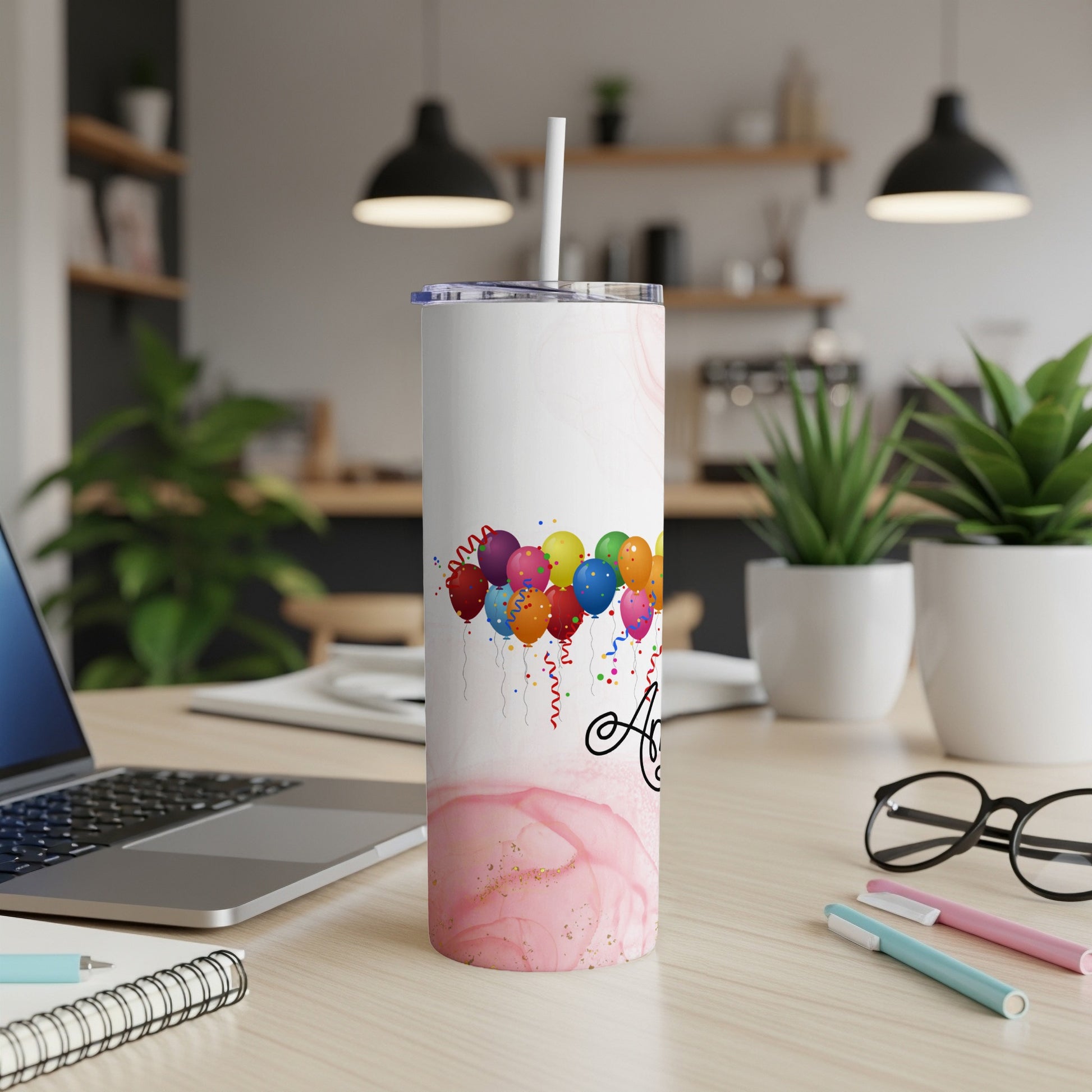 Tumbler with colorful balloons and "A" initial on a pink marble background.