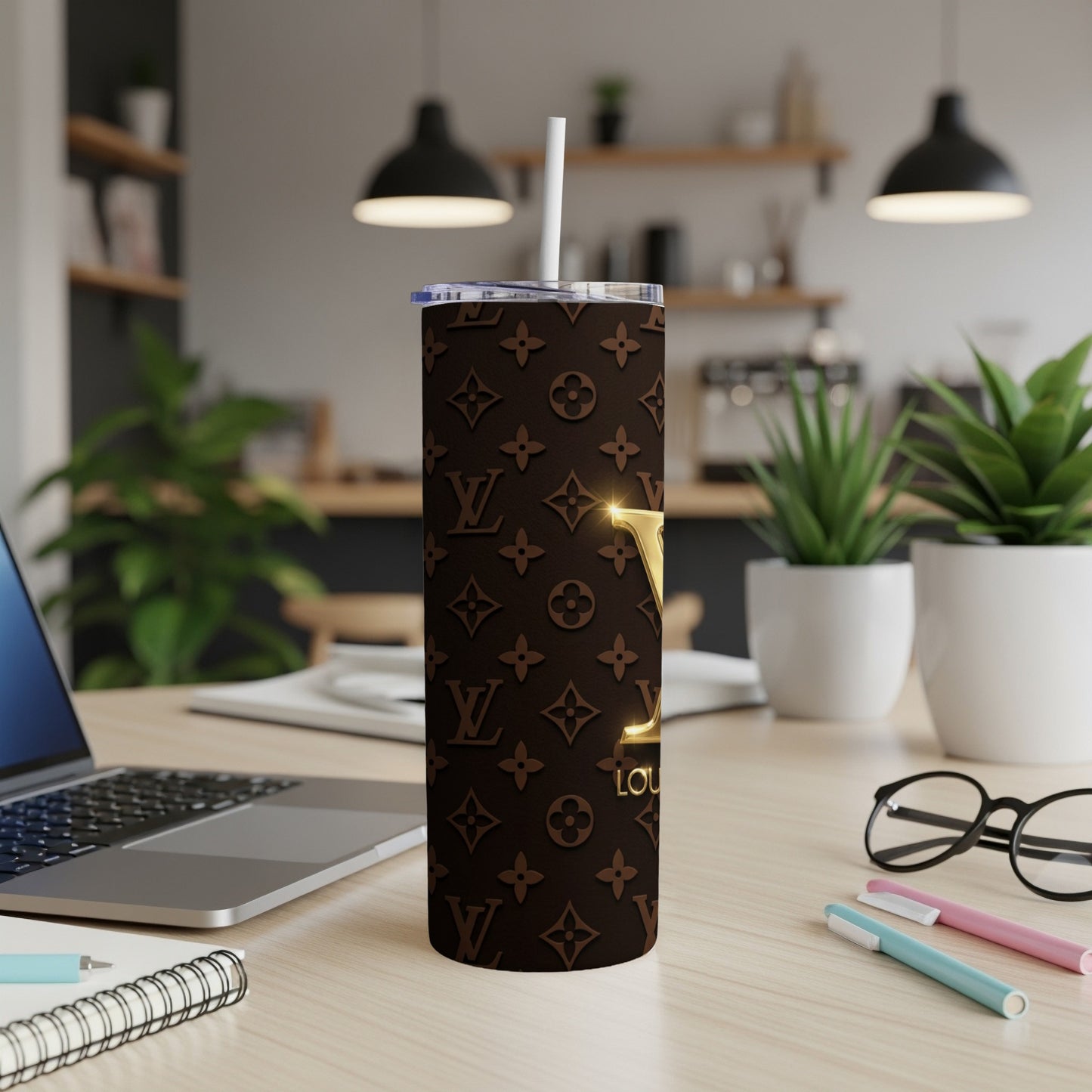 Brown tumbler with classic monogram pattern and gold logo, with straw.