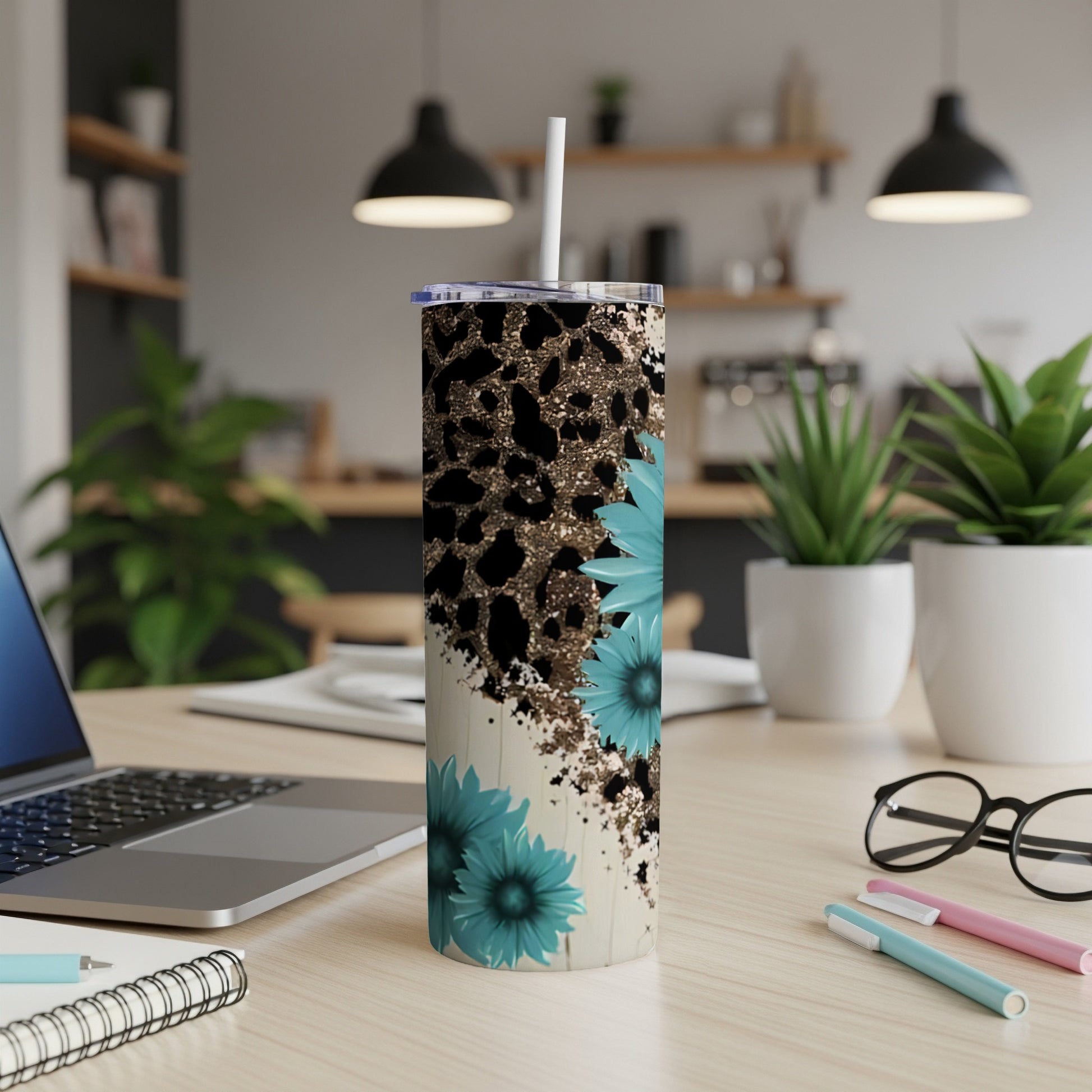 Leopard print and teal flower tumbler with straw on desk.
