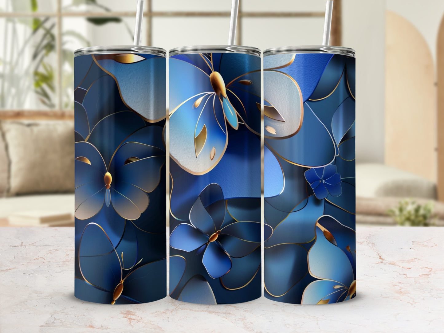 Three tumblers with blue floral and butterfly design, trimmed in gold.