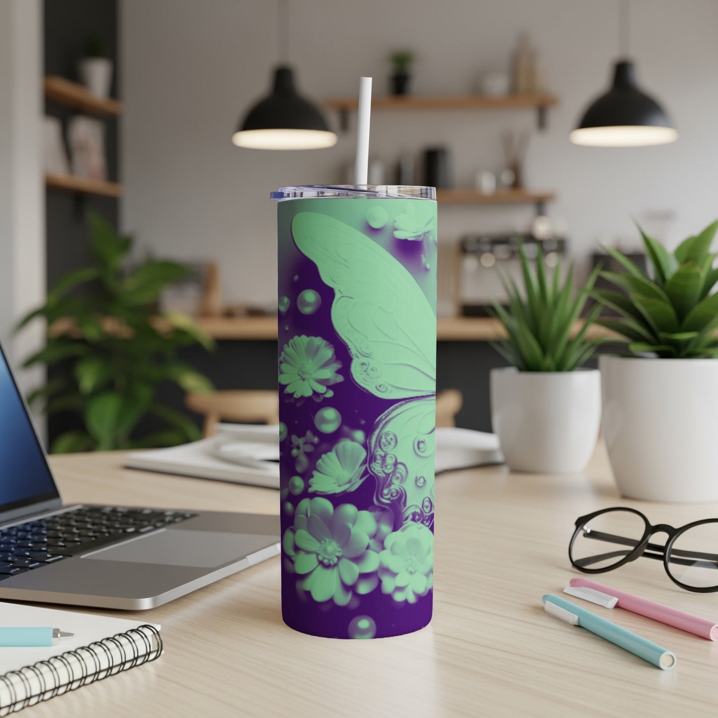 Purple and green butterfly and flower design on a tumbler with a straw.