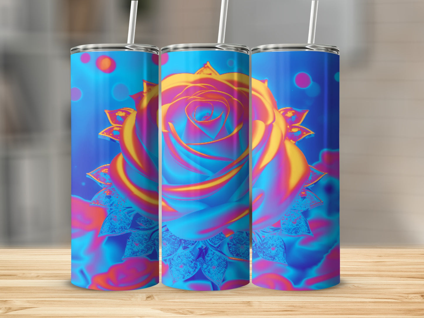 Three tumblers with vibrant floral rose design on a wooden surface.