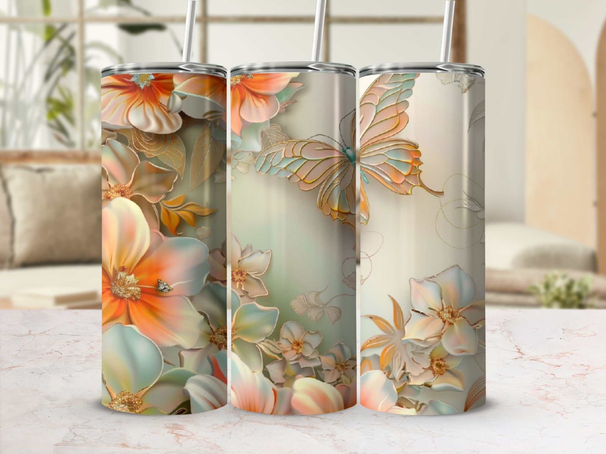 Three tumblers with floral and butterfly designs on a marble countertop.