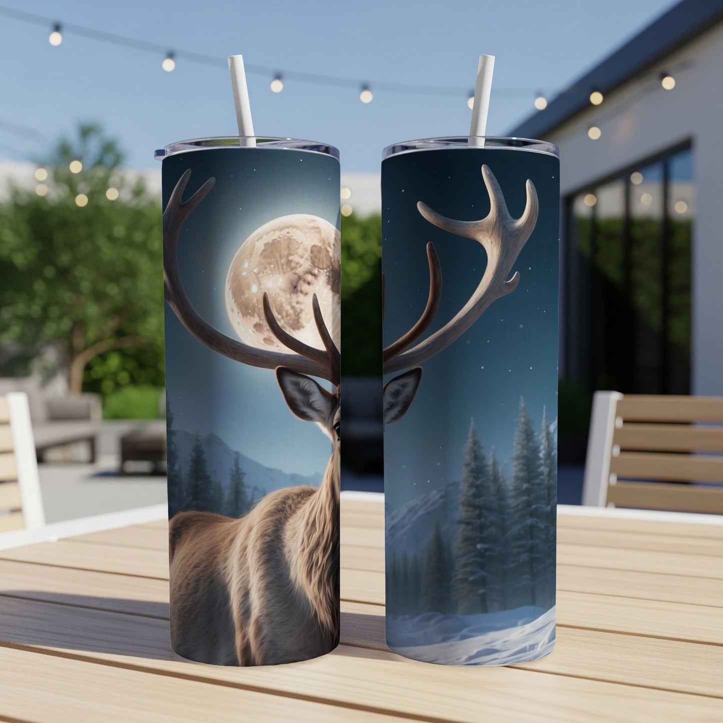 Two tumblers with a deer and moon design on an outdoor table.