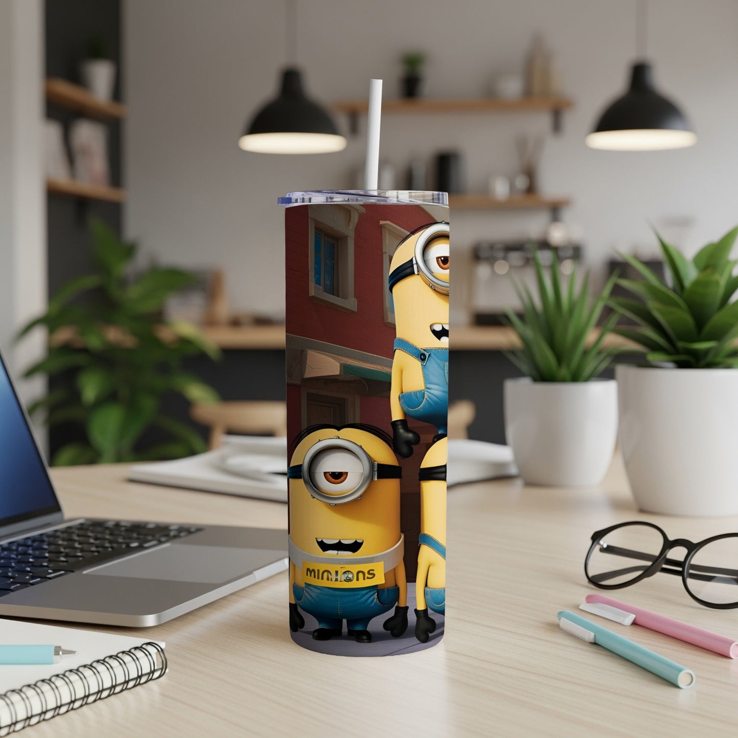 Minions characters on a blue and yellow patterned tumbler with a straw.