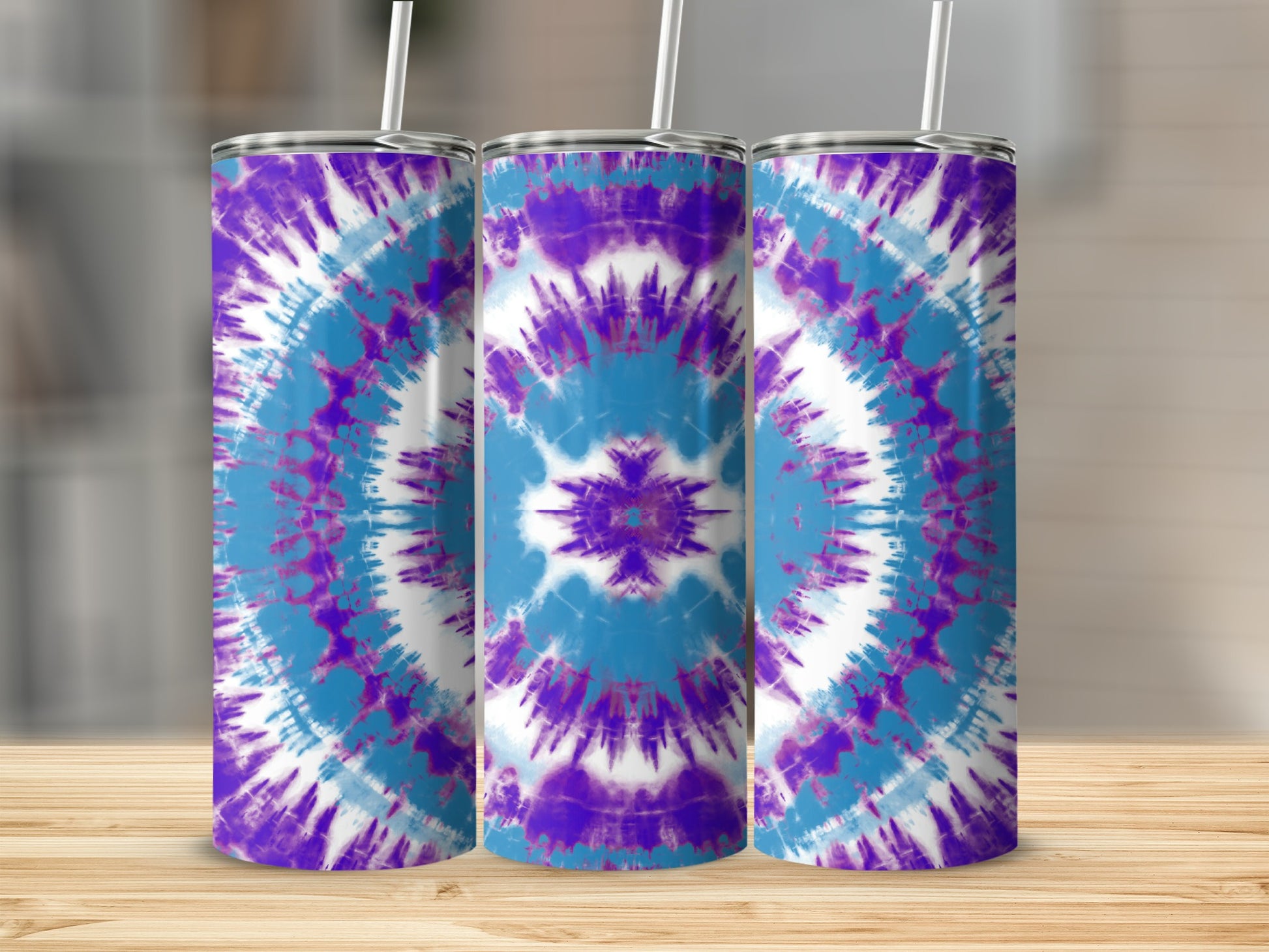 Three tumblers with purple, blue, and white tie-dye patterns stand on a wooden surface.