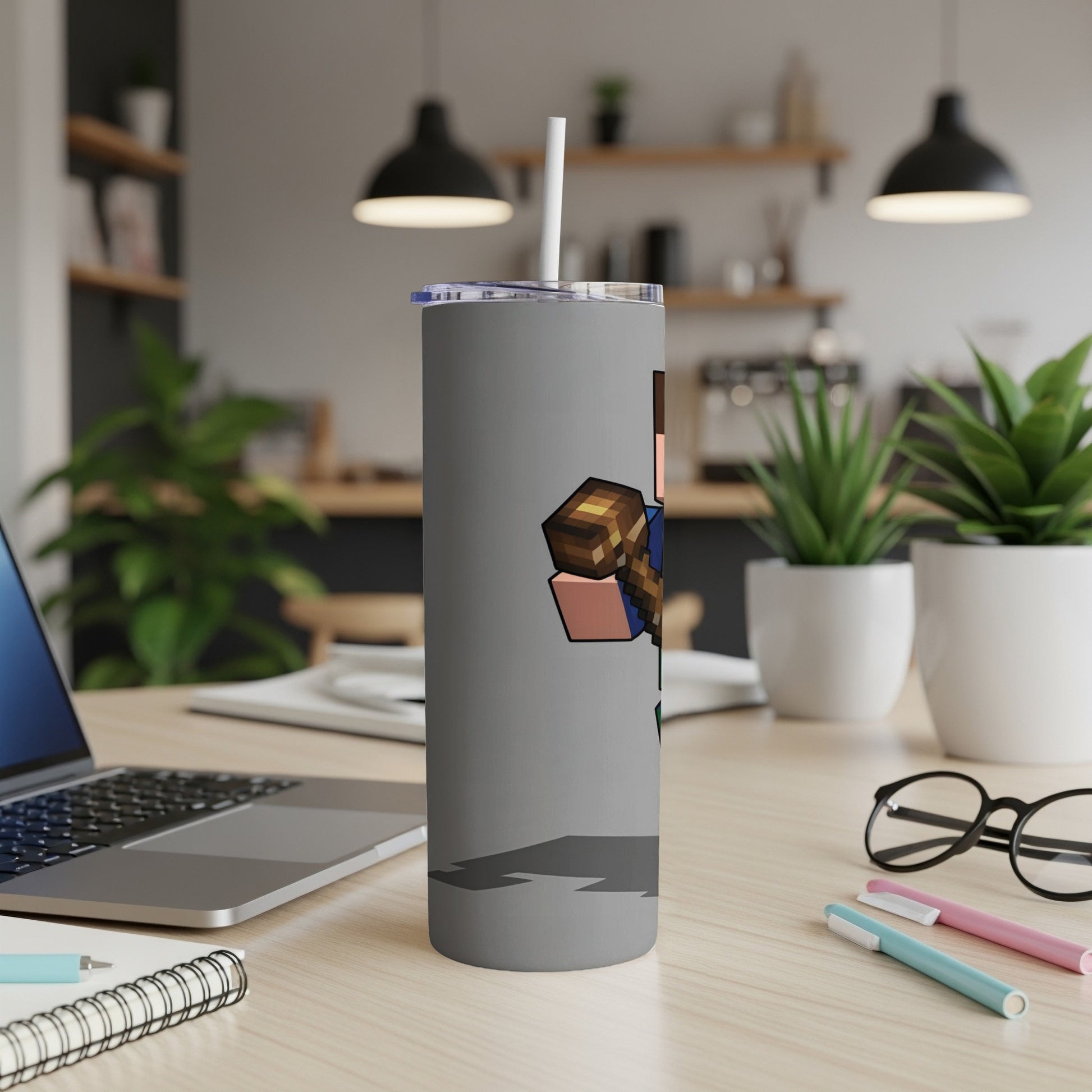 Gray tumbler featuring a Minecraft character holding an axe, on a desk.
